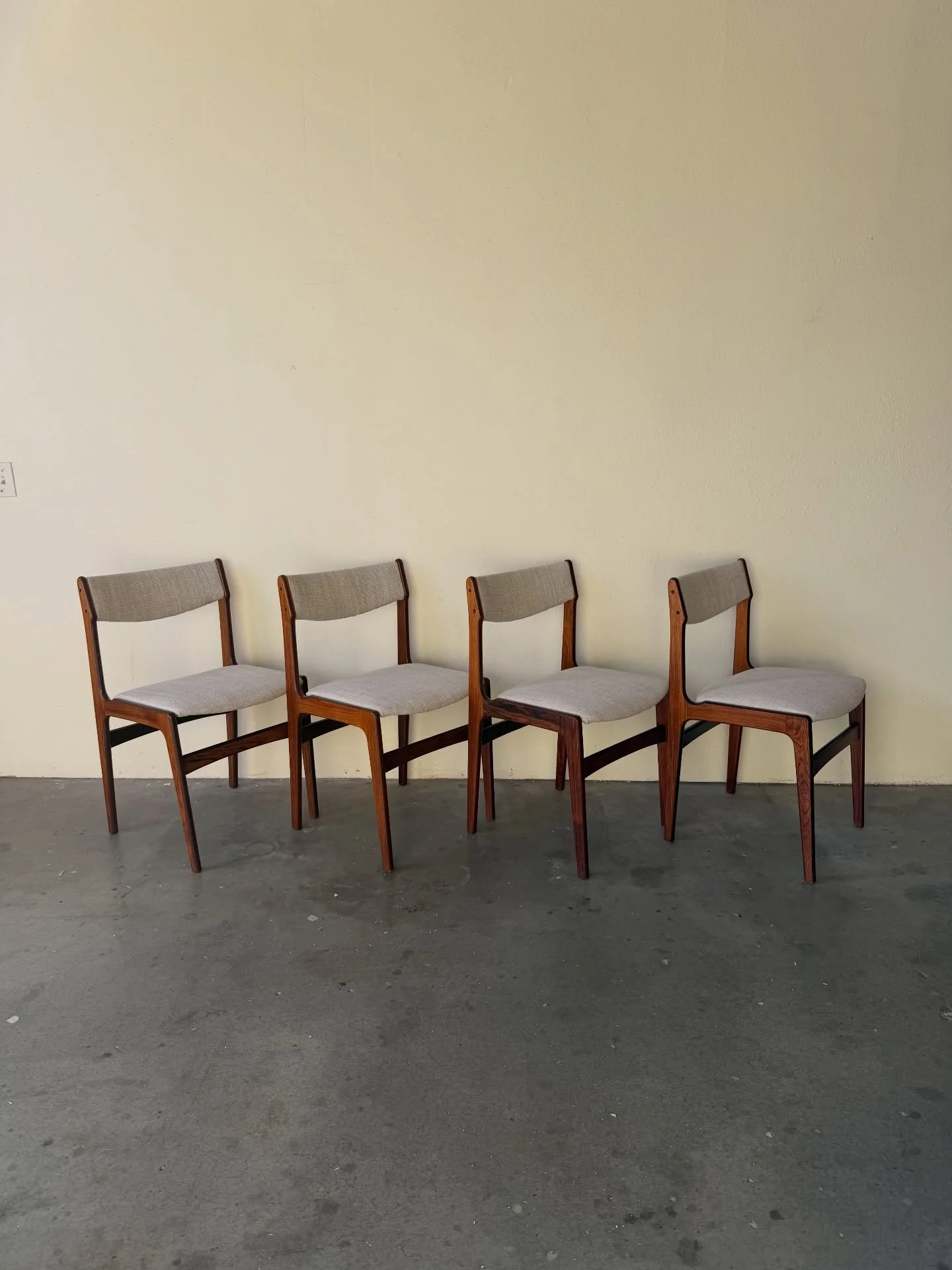Danish Mid-Century dining chairs by Erik Buch

Beautifully sculpted solid rosewood frames with the iconic angular profile characteristic of Erik Buch&rsquo;s designs. The seats and backs have been newly reupholstered in a neutral textured fabric, off
