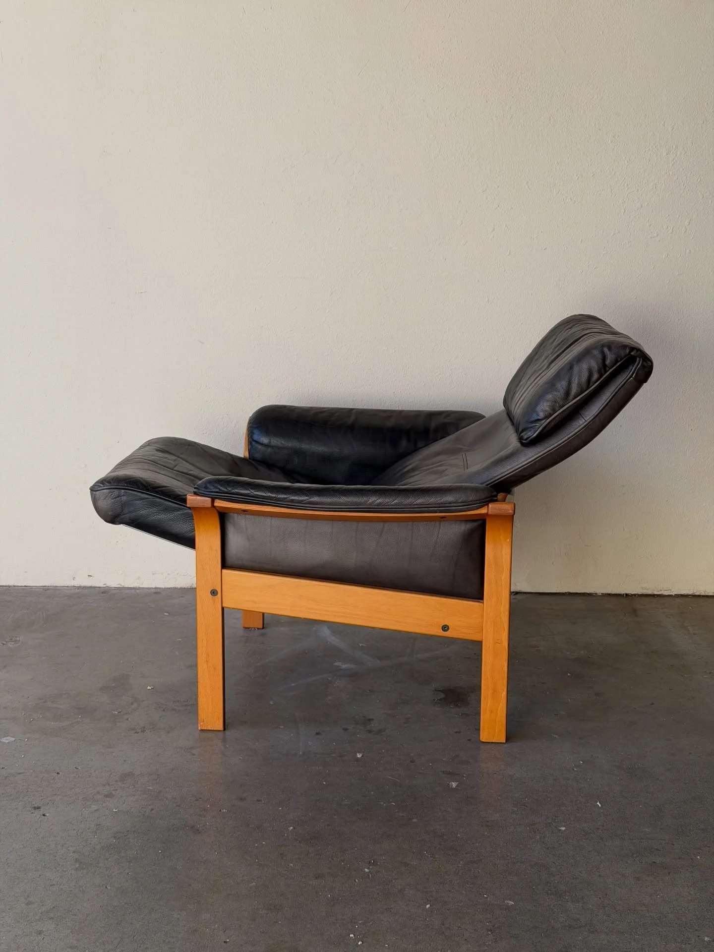 Vintage Swedish lounge armchair by G&ouml;te M&ouml;bler, featuring supple black leather upholstery and a solid light-wood frame. The chair offers an adjustable reclining mechanism for added comfort, perfect for relaxing, reading, or everyday loungin
