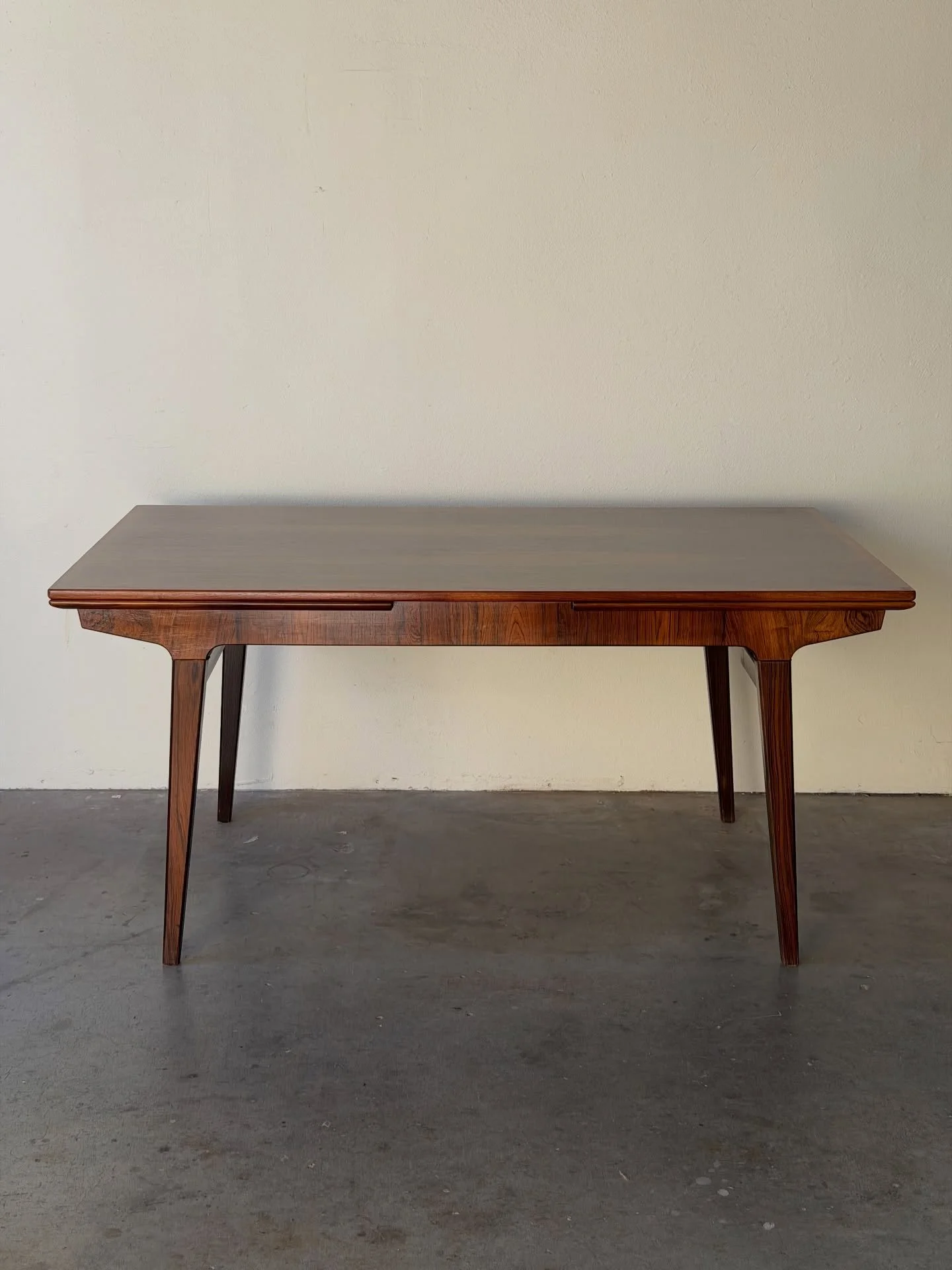 Beautiful vintage Danish rosewood dining table designed by Johannes Andersen. Sculptural base, refined tapered legs, and rich, expressive grain throughout.

Includes two extension leaves, expanding from a compact everyday size to a generous length fo