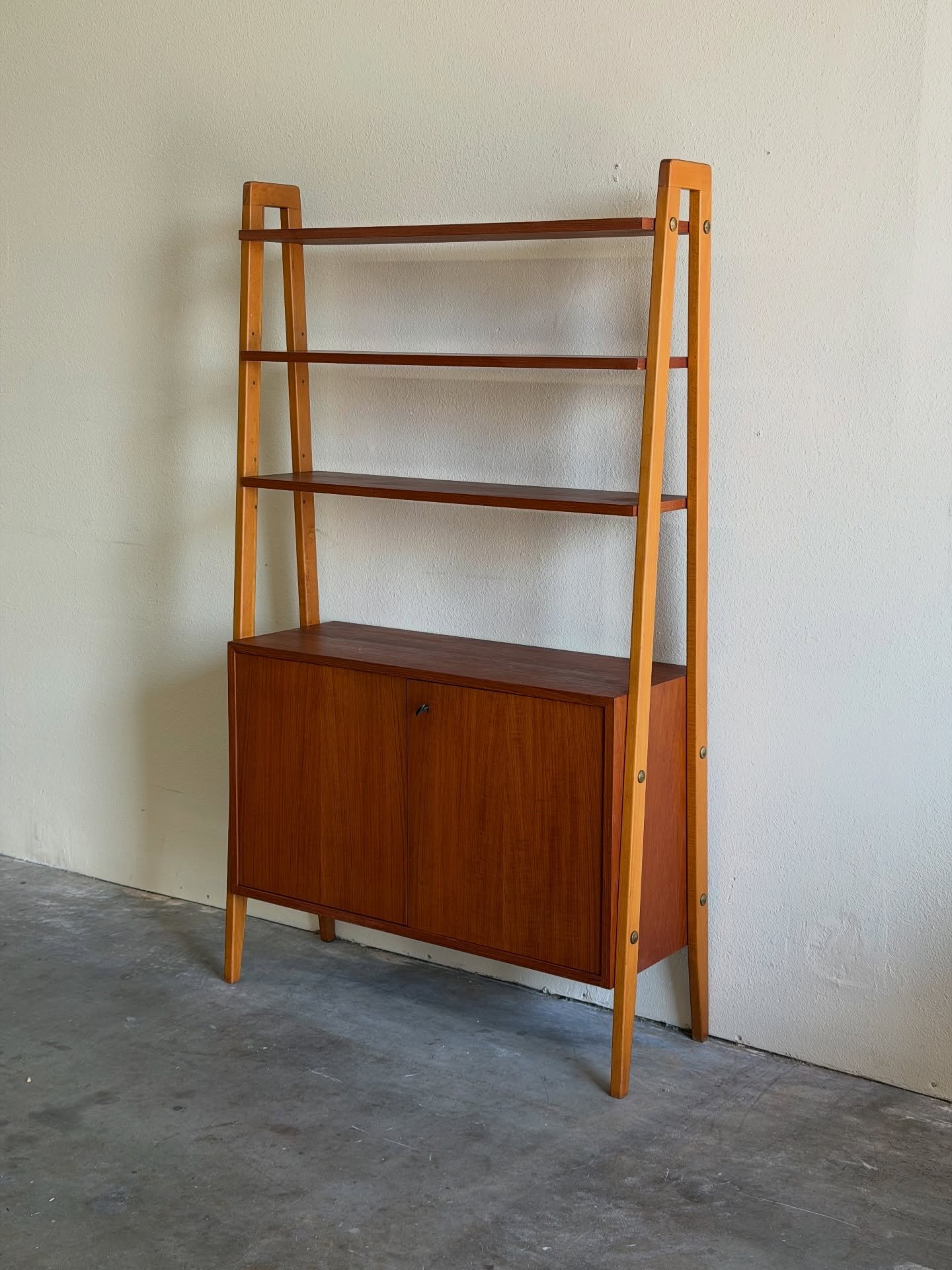 Swedish mid-century modern wall unit designed by Gillis Lundgren.

Crafted in warm teak, it features clean Scandinavian lines, open shelving for display, and a lower cabinet for concealed storage &mdash; a perfect mix of style and function.

Dimensio