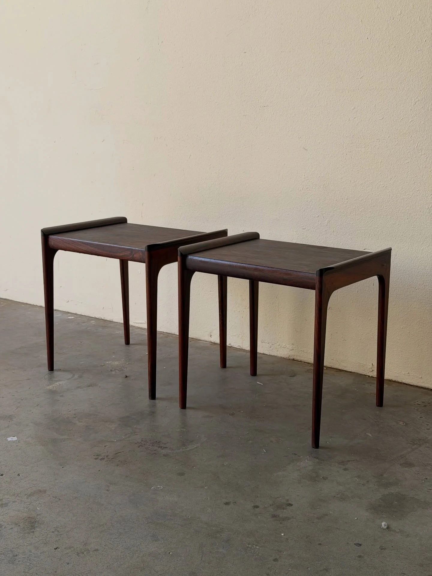 Pair of Danish rosewood nightstands by Heltborg M&oslash;bler  in rosewood, showcasing rich, expressive grain and refined Scandinavian lines. Tapered legs and clean proportions give them that effortless mid-century look.

Compact yet versatile &mdash