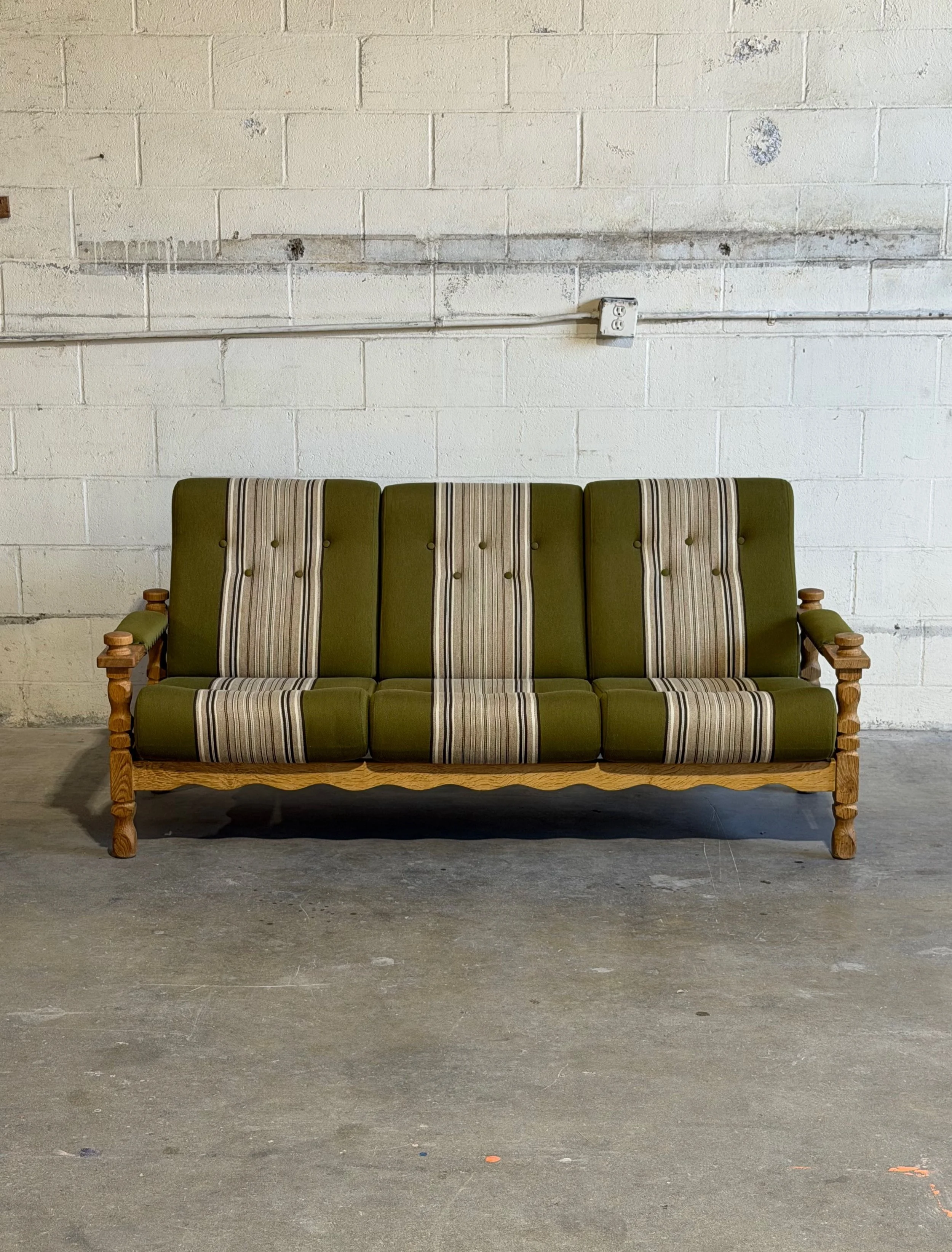 This sofa is seriously beautiful 

Danish three-seat sofa designed by Henning Kj&aelig;rnulf, featuring sculptural solid oak construction and rich green striped upholstery that feels both bold and timeless at the same time 

The carved arm details, t
