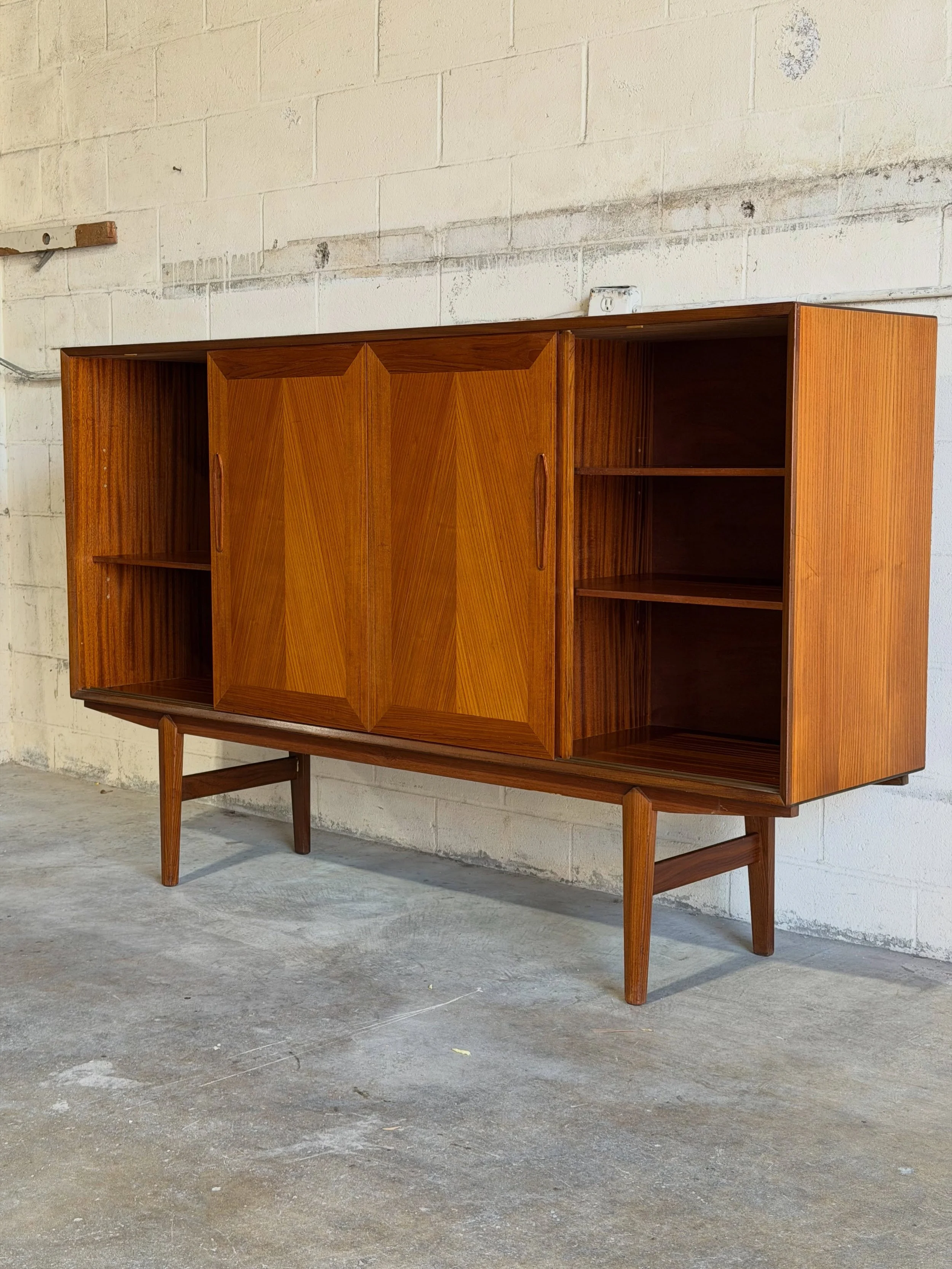 One of the coolest bar cabinets from our latest container 

Beautiful Danish modern highboard by Jensen &amp; Rasnov, crafted in warm teak with striking chevron sliding doors.

The real surprise is inside &mdash; a stunning rosewood and mirrored bar 