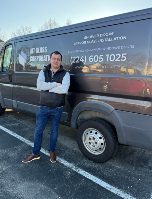 Man standing in front of a black van with company information for MT Glass Corporation, which installs shower doors, mirror glass, and commercial aluminum windows and doors.