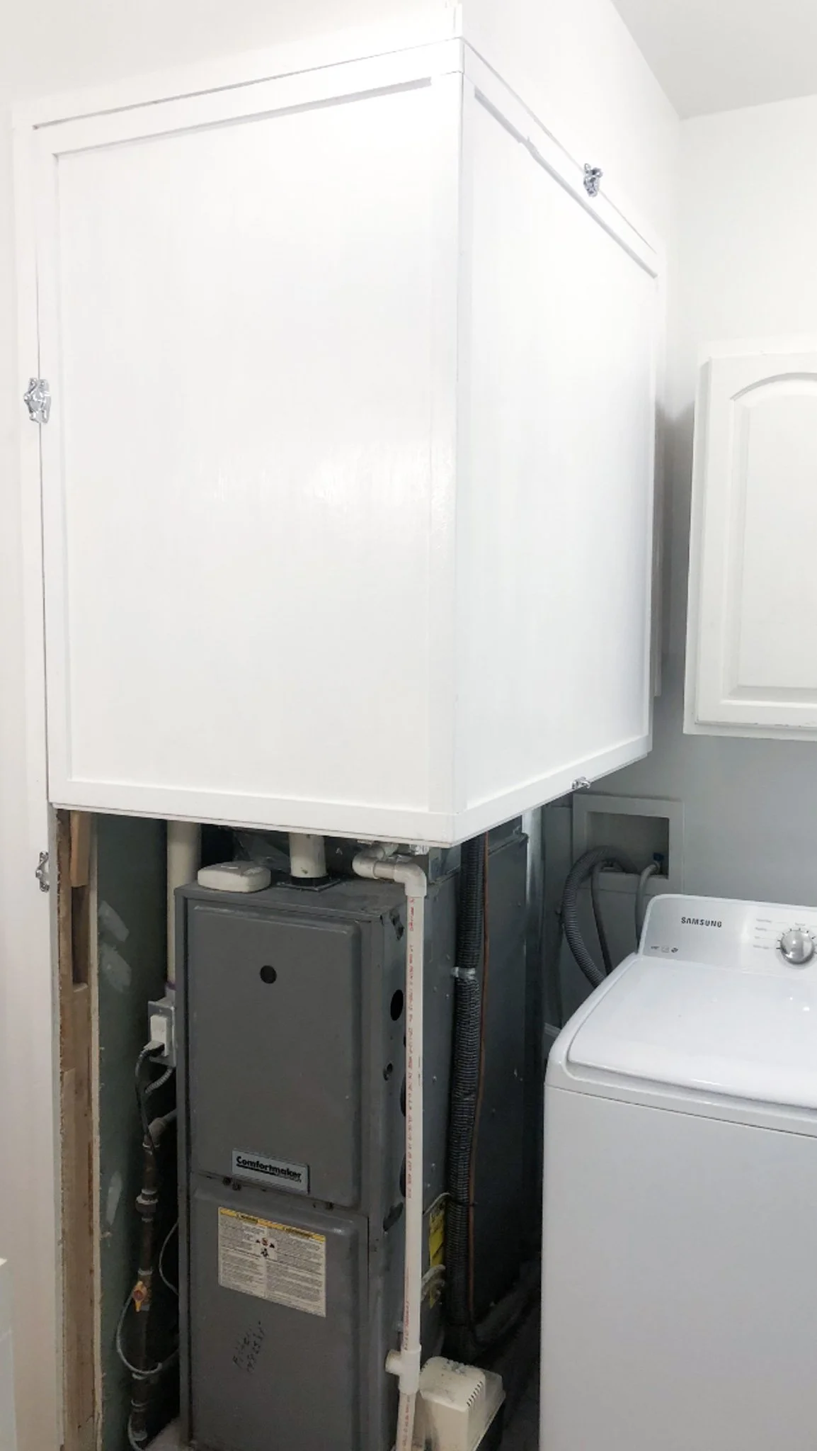 In‑progress build showing white upper box covering top portion of furnace during faux cabinet project in Boise, Idaho