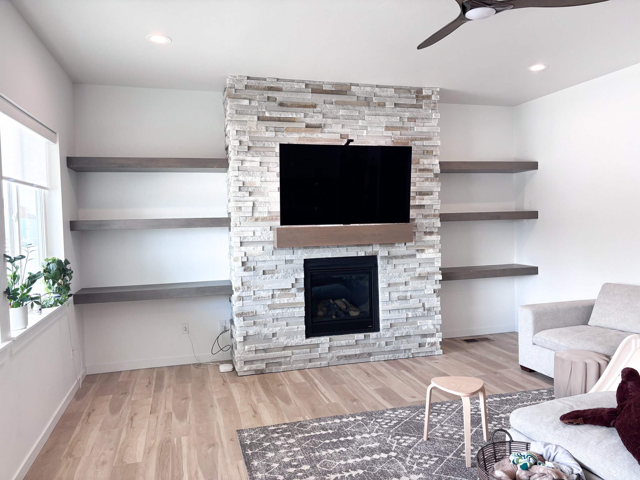 This show the finished project with the floating shelves flanking the stone fireplace in the customer's home in Kuna, Idaho.