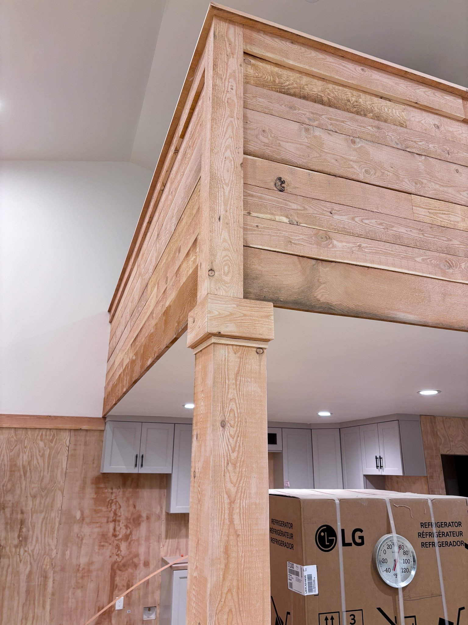 Close‑up of Eagle, Idaho loft balcony showing raw wood planks attached to railing posts before staining