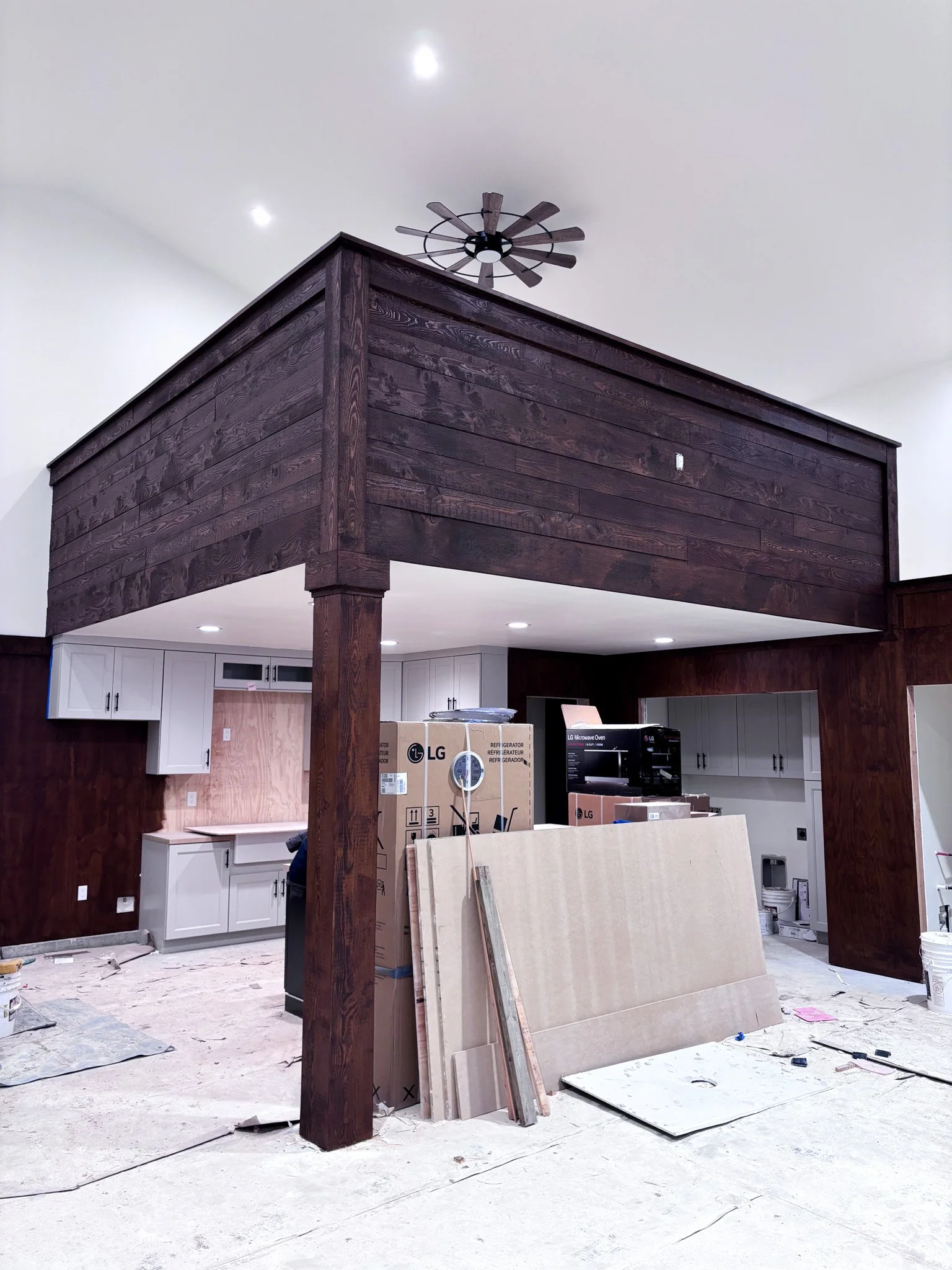 Finished dark‑stained wood wall paneling wrapping around loft with ceiling fan, Eagle, Idaho