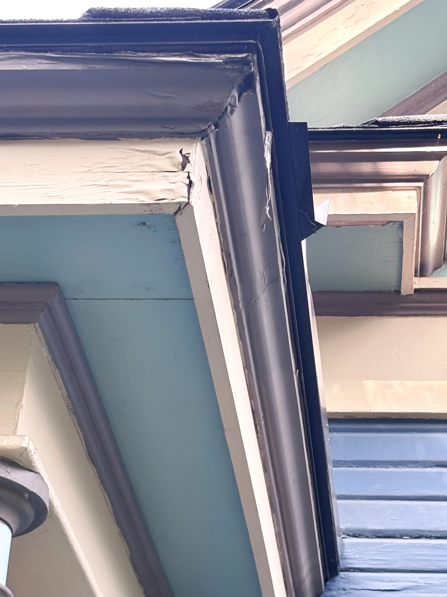 Close‑up of before picture of gutter on historic Garden City home