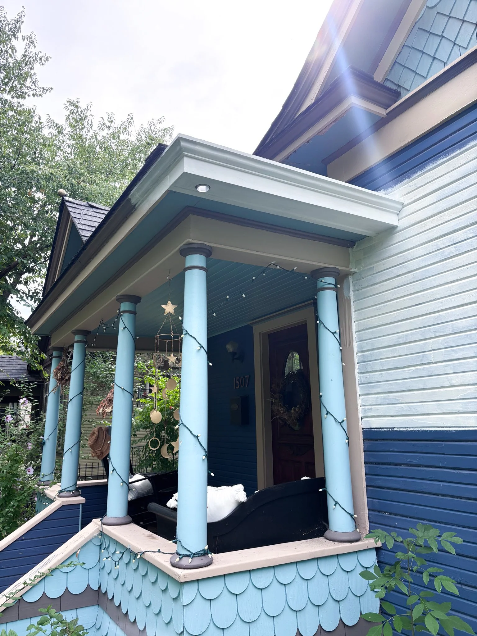 Completed front porch with hidden gutter integrated under scalloped trim, preserving historic look in Garden City, Idaho