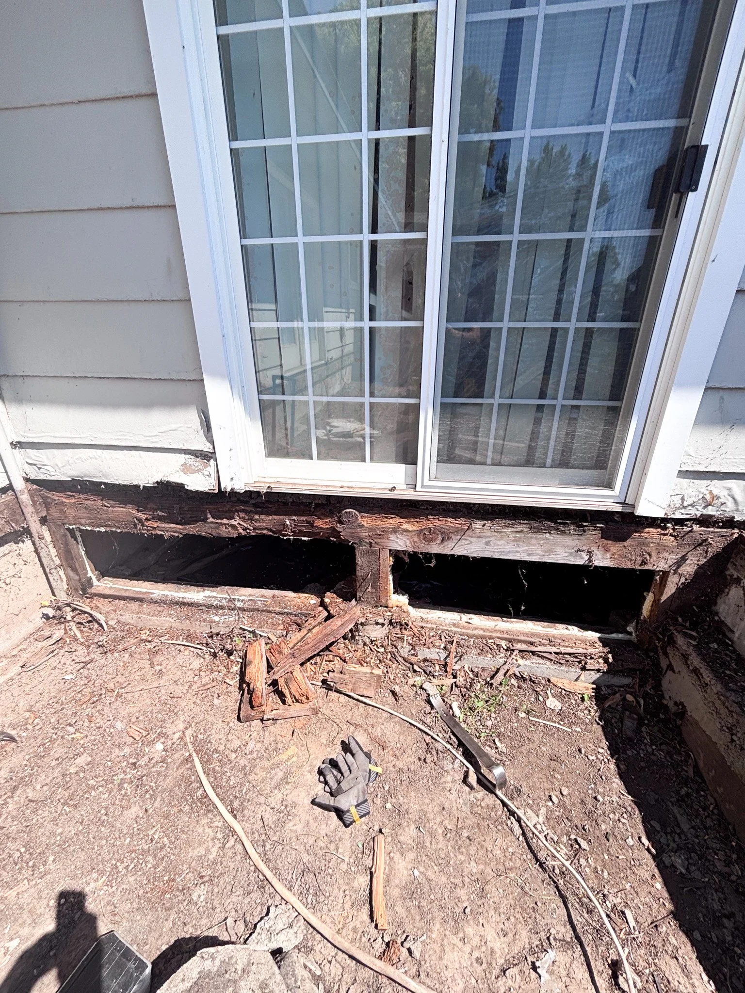  Rotten deck support beams removed beneath sliding patio door exposing crawlspace during replacement in New Plymouth, Idaho