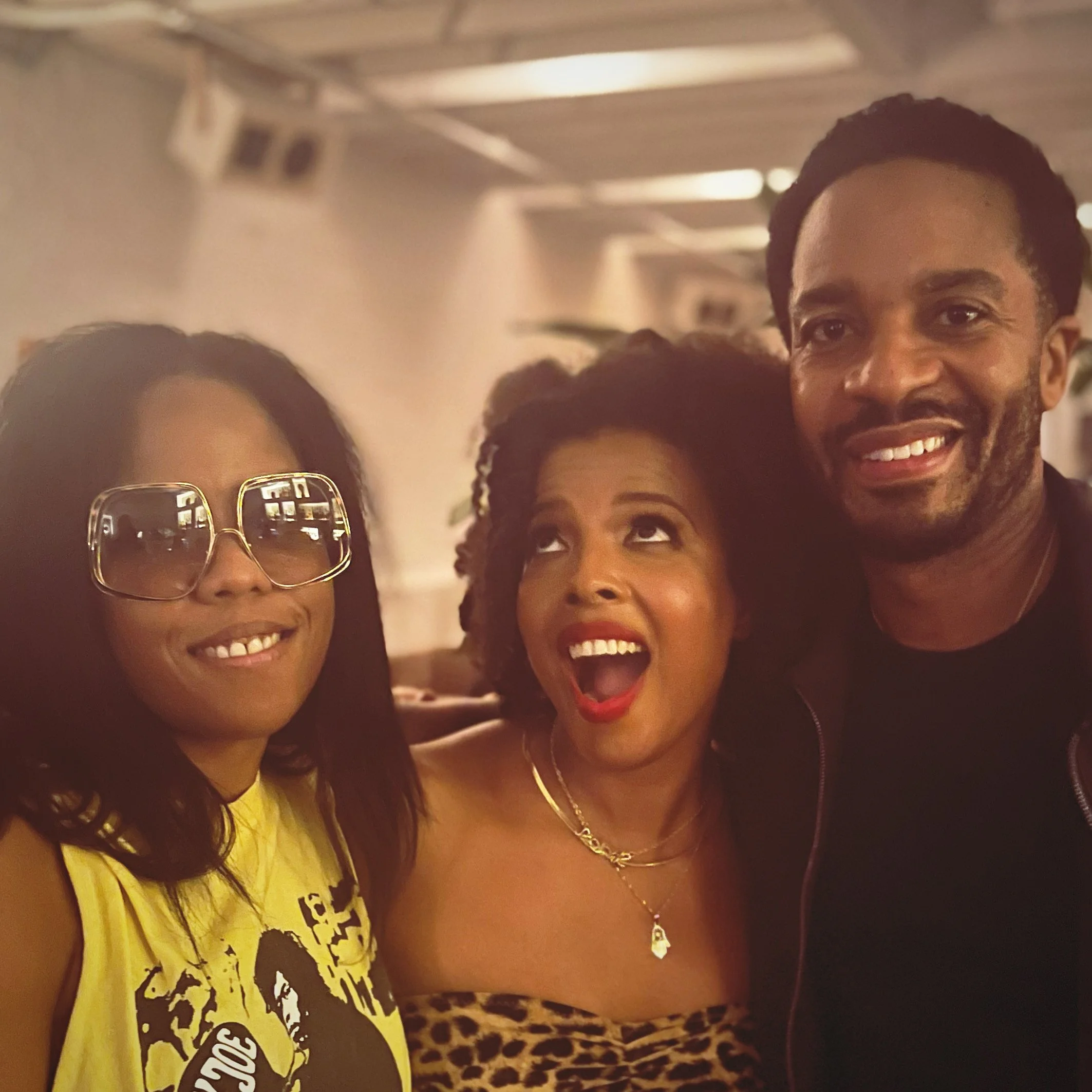 Three people smiling and posing for a photo indoors at a Babel social event.