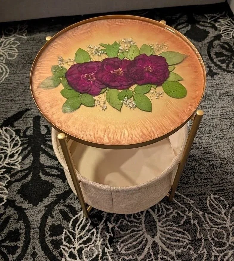 Top-down view of Faneology resin table with dark pink roses on a patterned rug