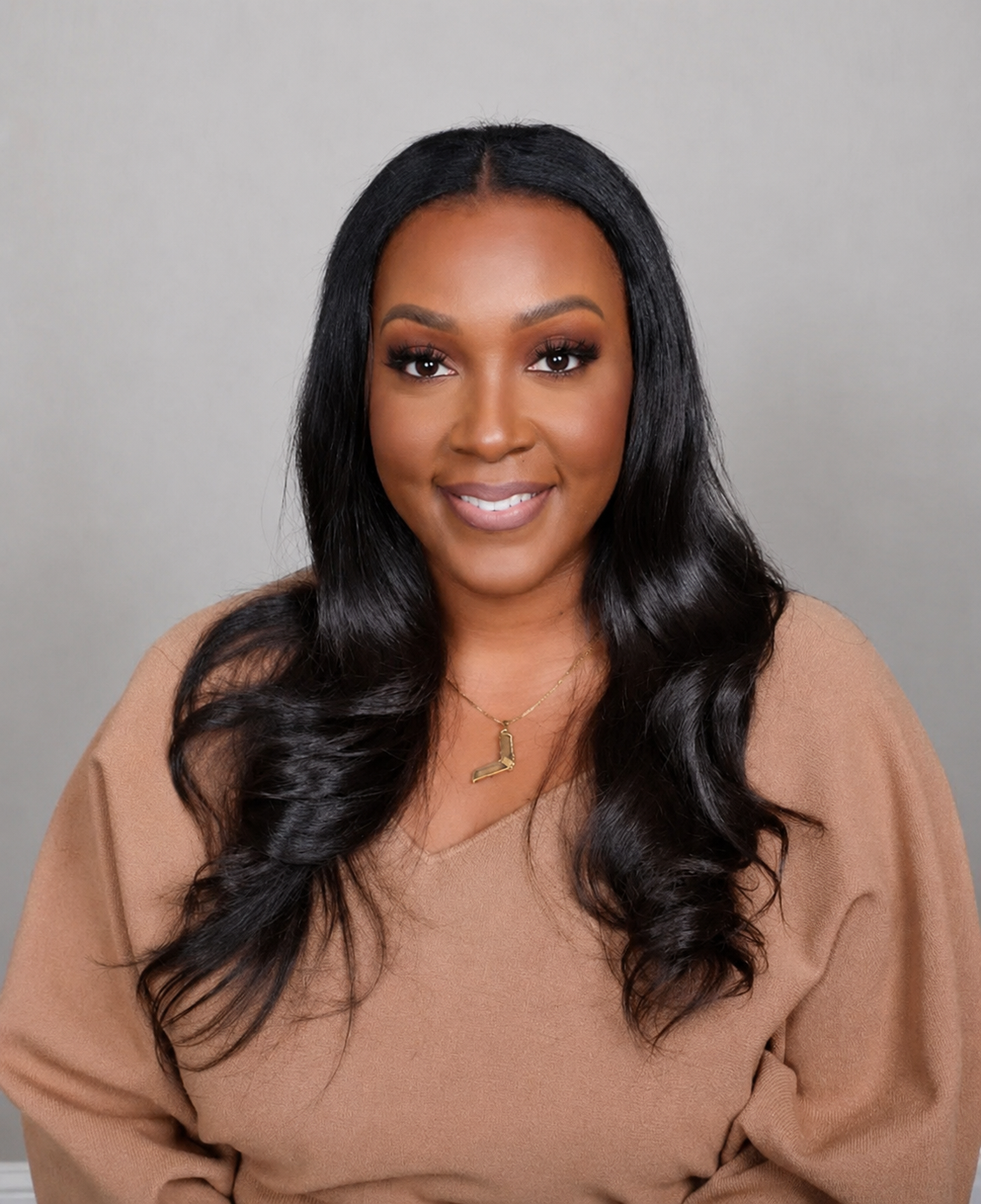 Kimberly Lewis, PMHNP headshot image. She is sitting wearing a clay colored shirt and L shaped necklace.