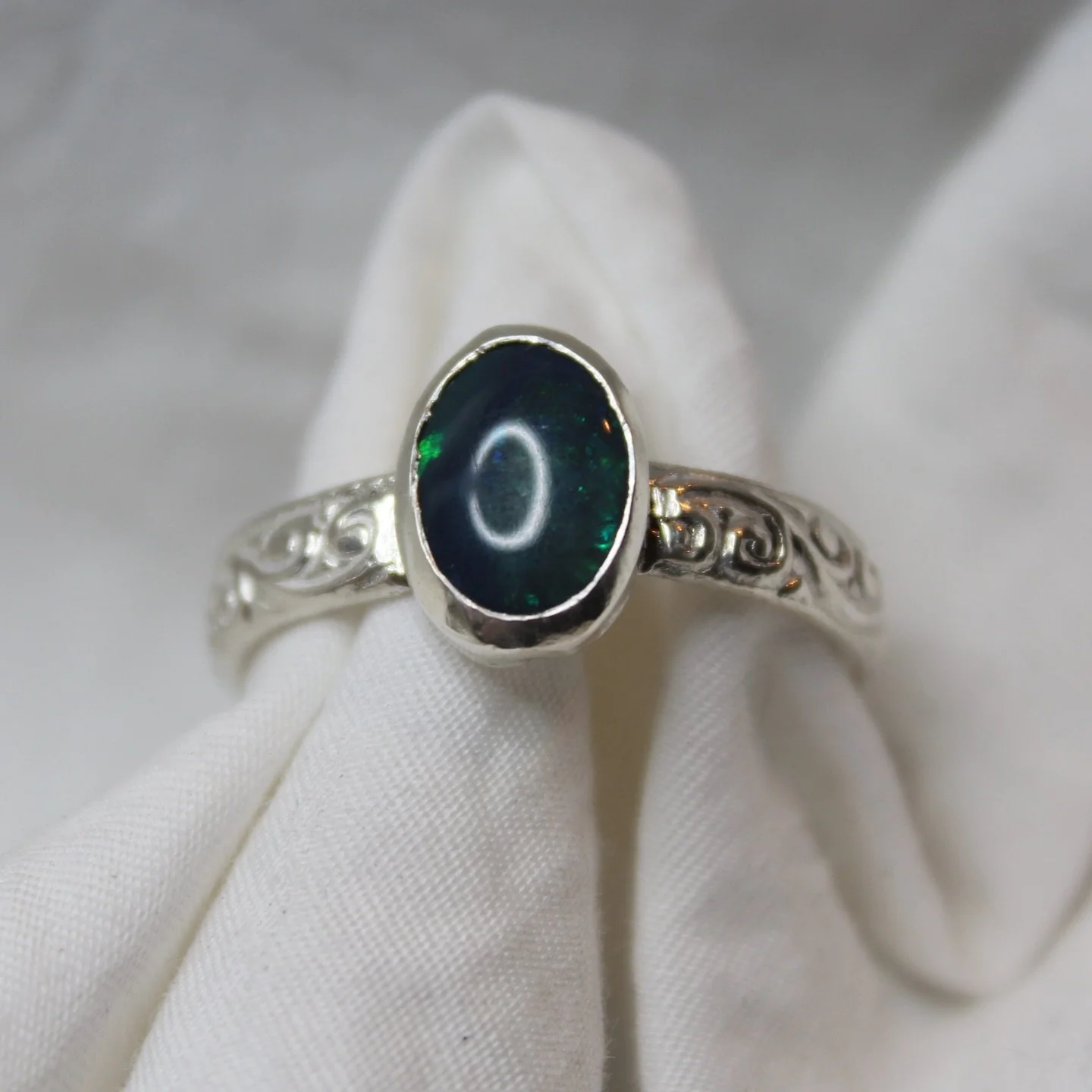 hard to capture how pretty this aussie opal really is but its got this amazing opacity running through the middle with flashes of green &amp; yellow. set in a sterling silver swirl band to compliment the complex colour palette #silver #sterlingsilver