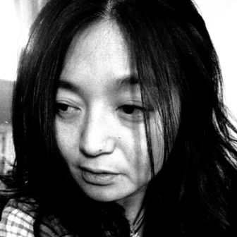 Close-up black and white photo of a young woman with long dark hair looking to the side.