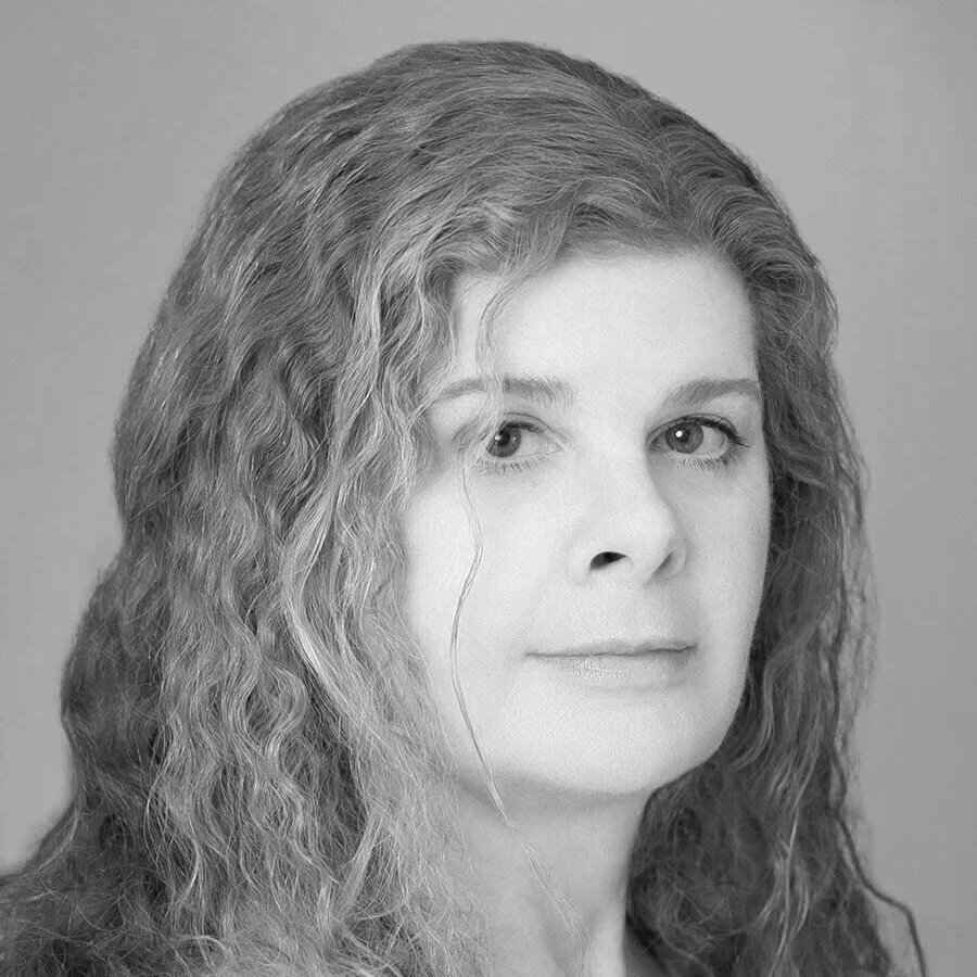 Black and white portrait of a woman with wavy hair looking at the camera.