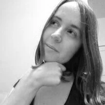 Black and white photo of a woman looking to the side with a thoughtful expression, resting her chin on her hand.