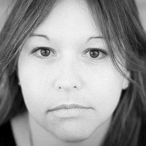 Close-up of a woman's face in black and white, showing her eyes, nose, and lips.