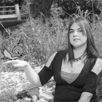 Young woman with long hair and a choker necklace, standing outdoors with plants and a butterfly, holding out her hand.