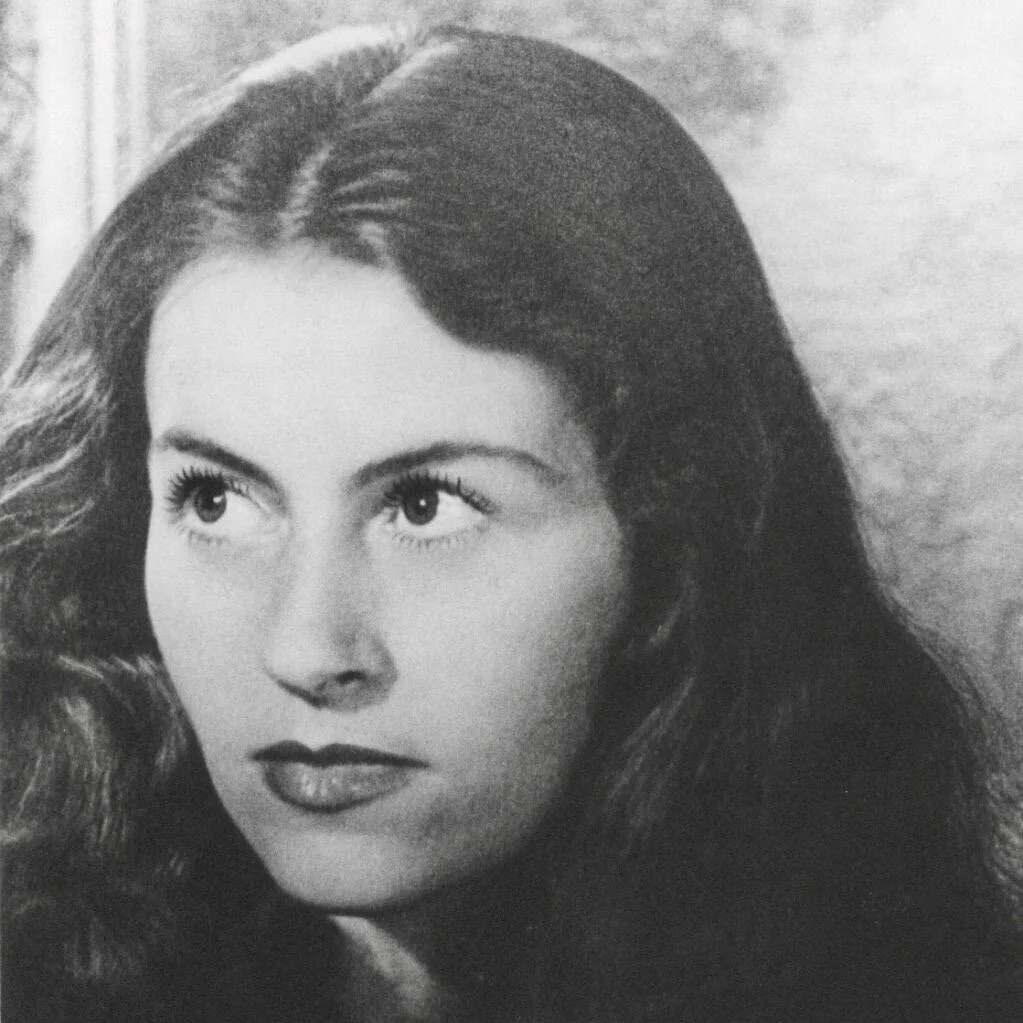 Black and white portrait of a woman with long wavy hair, looking slightly to the side with a thoughtful expression.