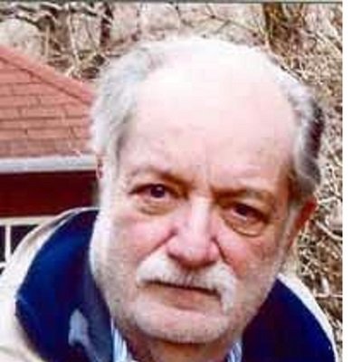 Close-up of an elderly man with a mustache and gray hair outdoors