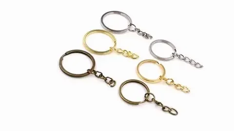 Six metal keychains in various colors, arranged in a semi-circle on a white background.