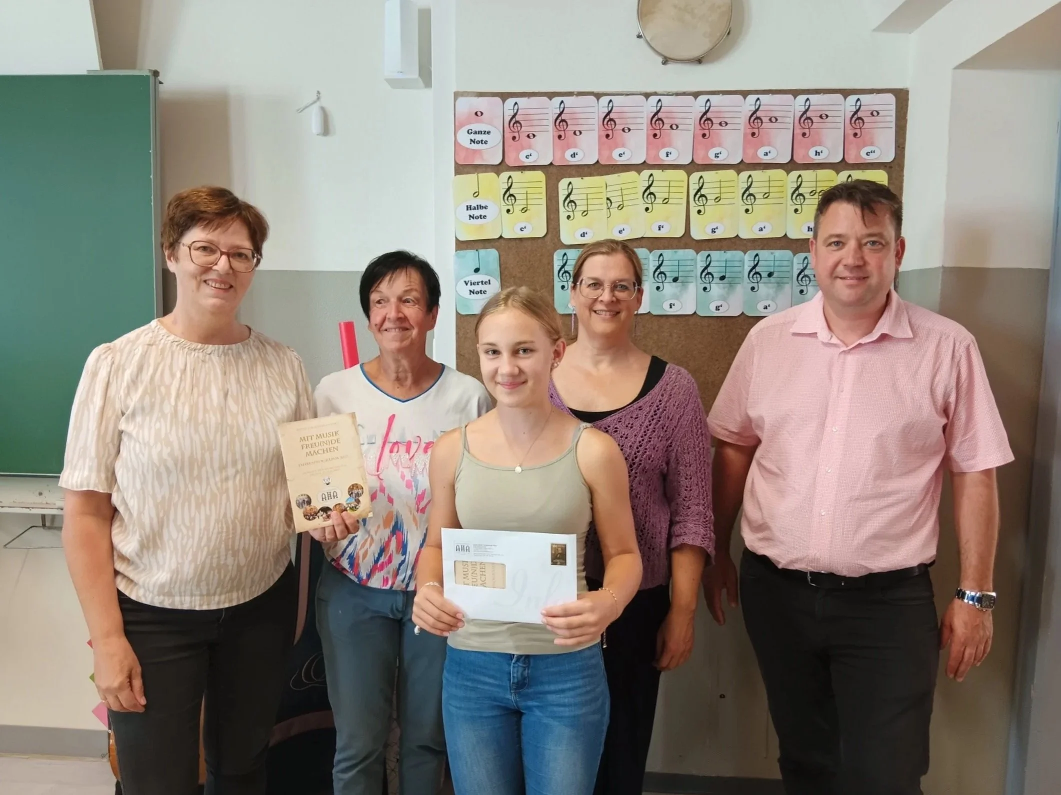 Überreichung des Förderstipendiums "AntonHalm4Kids" 2025 der Anton Halm-Gesellschaft an Malia Michl in einem Klassenzimmer der Erzherzog Johann Musikschule Wies. Anwesend sind u. A. Obfrau Waltraud Waltl und Musikschuldirektor Franz Masser.