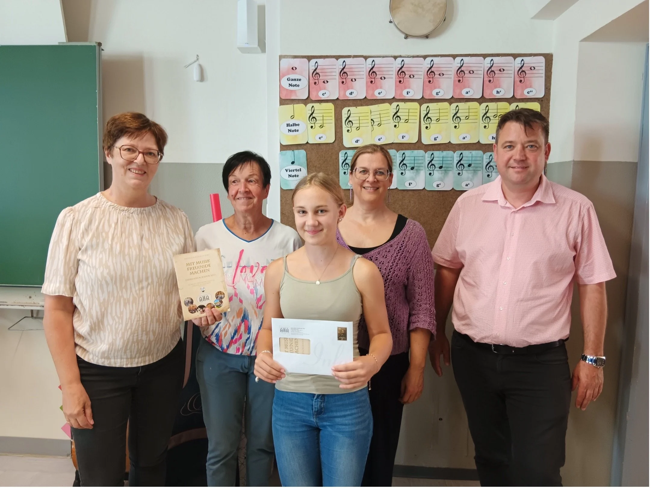 Überreichung des Förderstipendiums "AntonHalm4Kids" 2025 der Anton Halm-Gesellschaft an Malia Michl in einem Klassenzimmer der Erzherzog Johann Musikschule Wies. Anwesend sind u. A. Obfrau Waltraud Waltl und Musikschuldirektor Franz Masser.