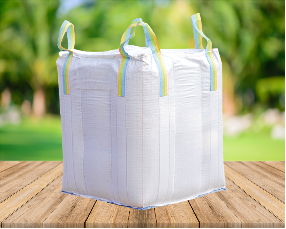 A large white sack with rainbow-colored straps placed on a wooden surface outdoors.