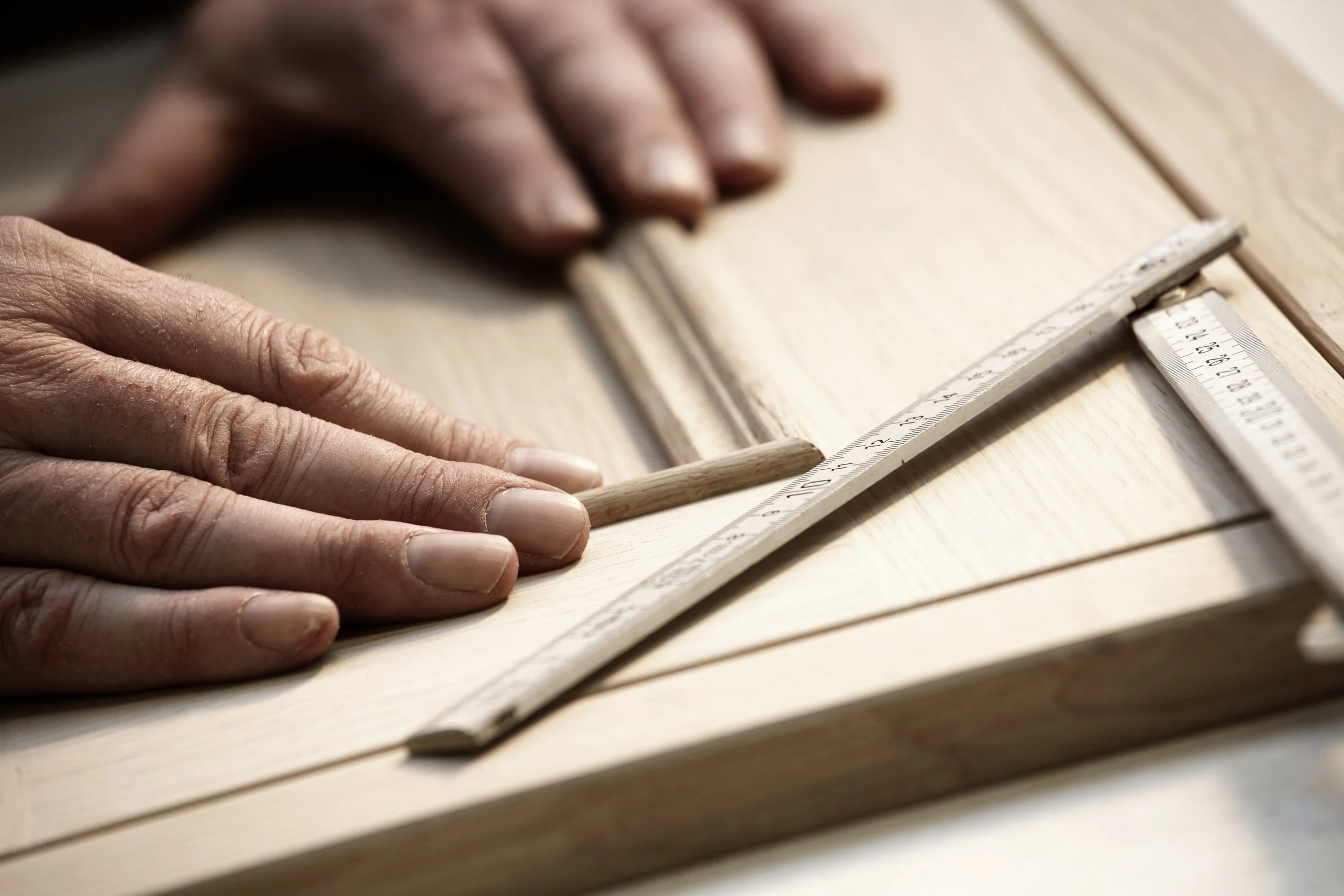 Handcrafted kitchen cabinetry being shaped by an artisan, highlighting bespoke joinery for luxury North London kitchens