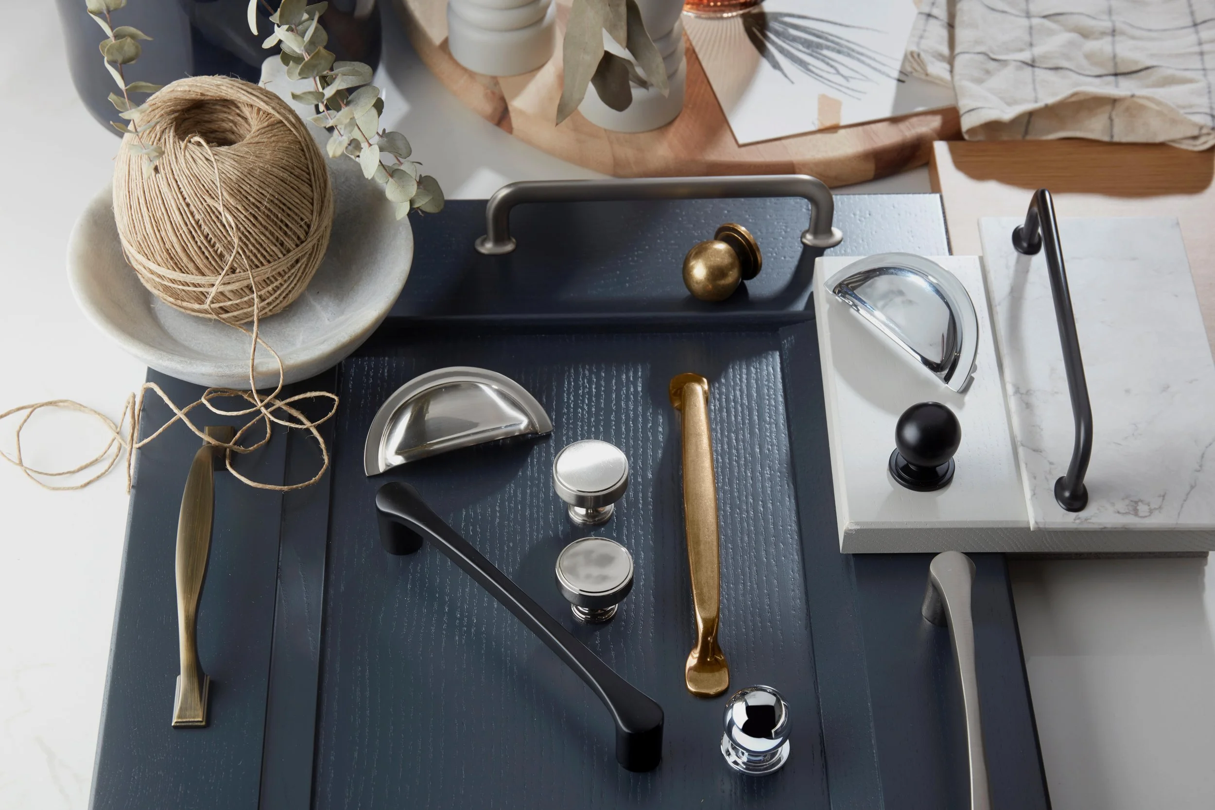 Premium kitchen handles and knobs for bespoke North London kitchens, shown in mixed finishes on sample cabinet panels