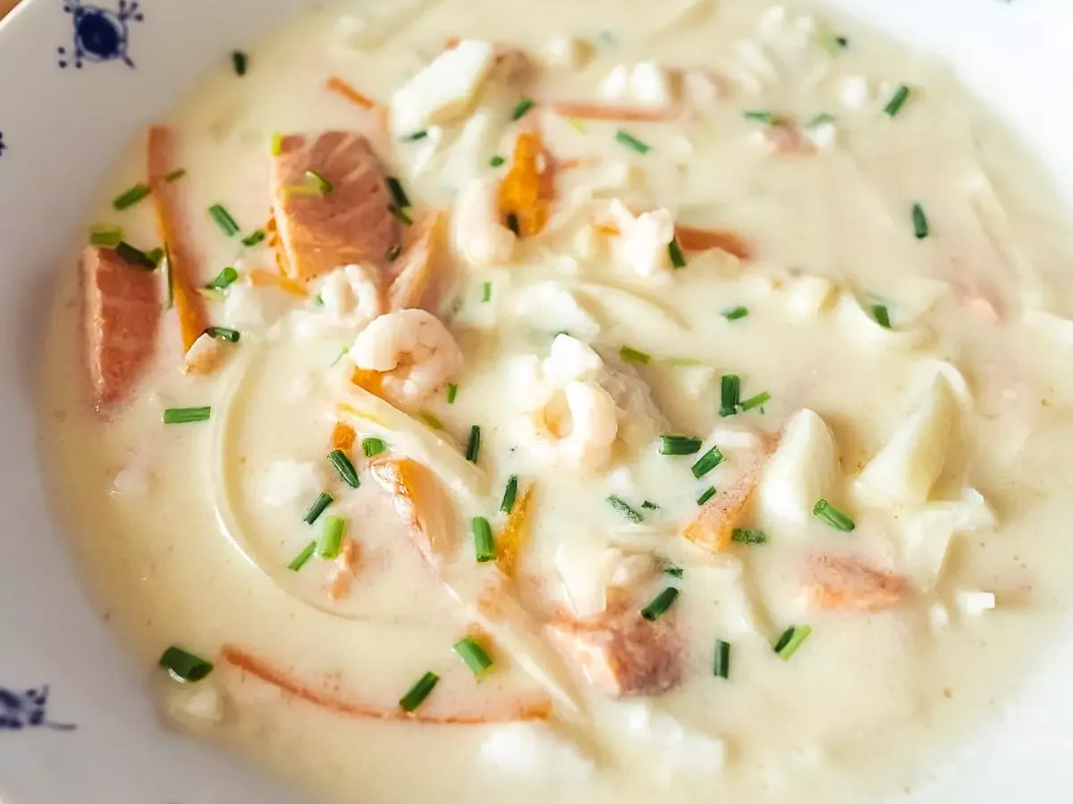 Traditional fiskesuppe in Trondheim, Norway, creamy Norwegian fish soup with cod, shrimp and root vegetables
