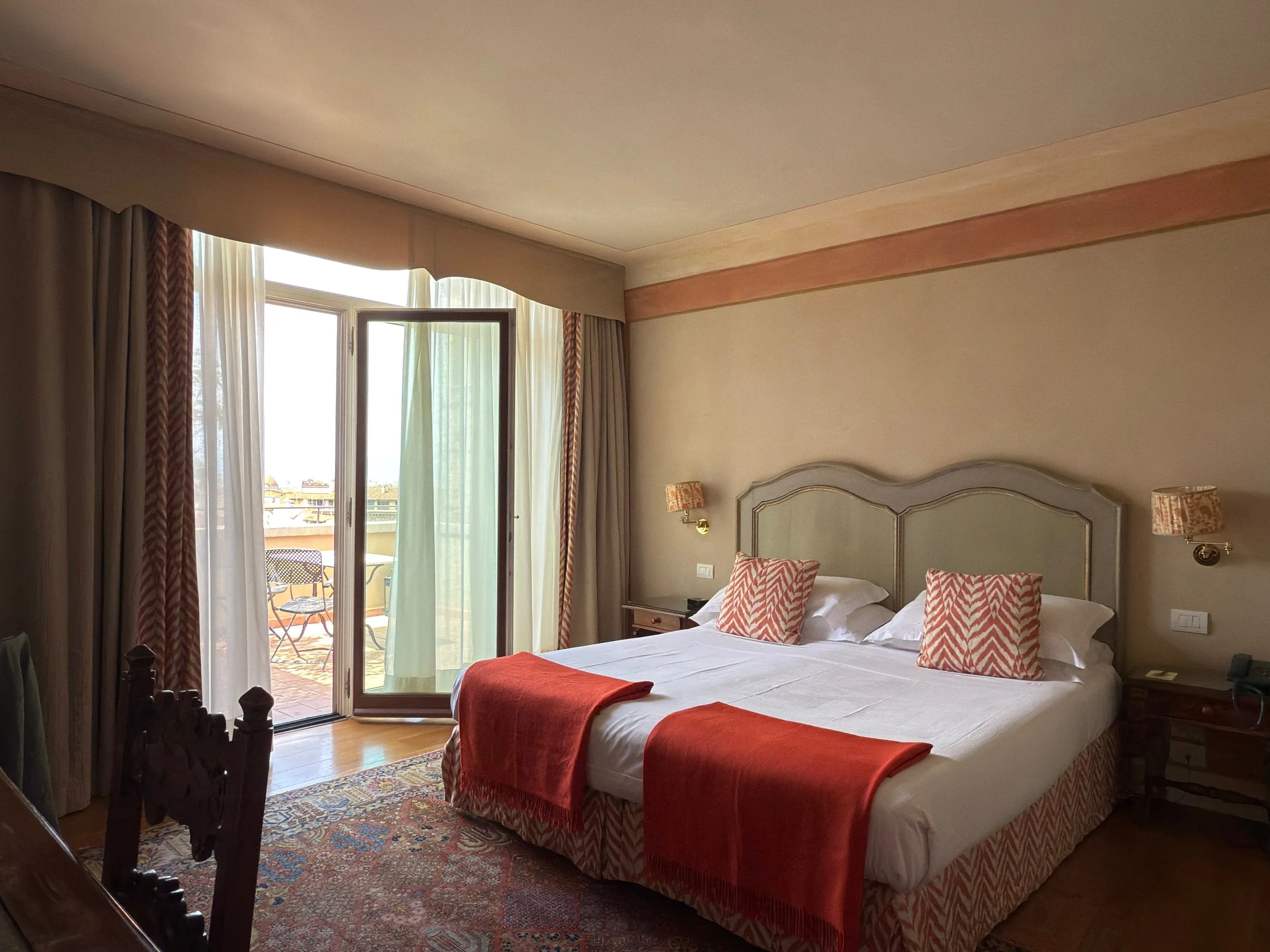 Profumo di Santa Maria Novella Room Florence luxury hotel featuring a white linen king bed, Renaissance-style interiors, wooden floors, and a honey-veined marble bathroom with toiletries by Antica Officina Profumo di Santa Maria Novella.