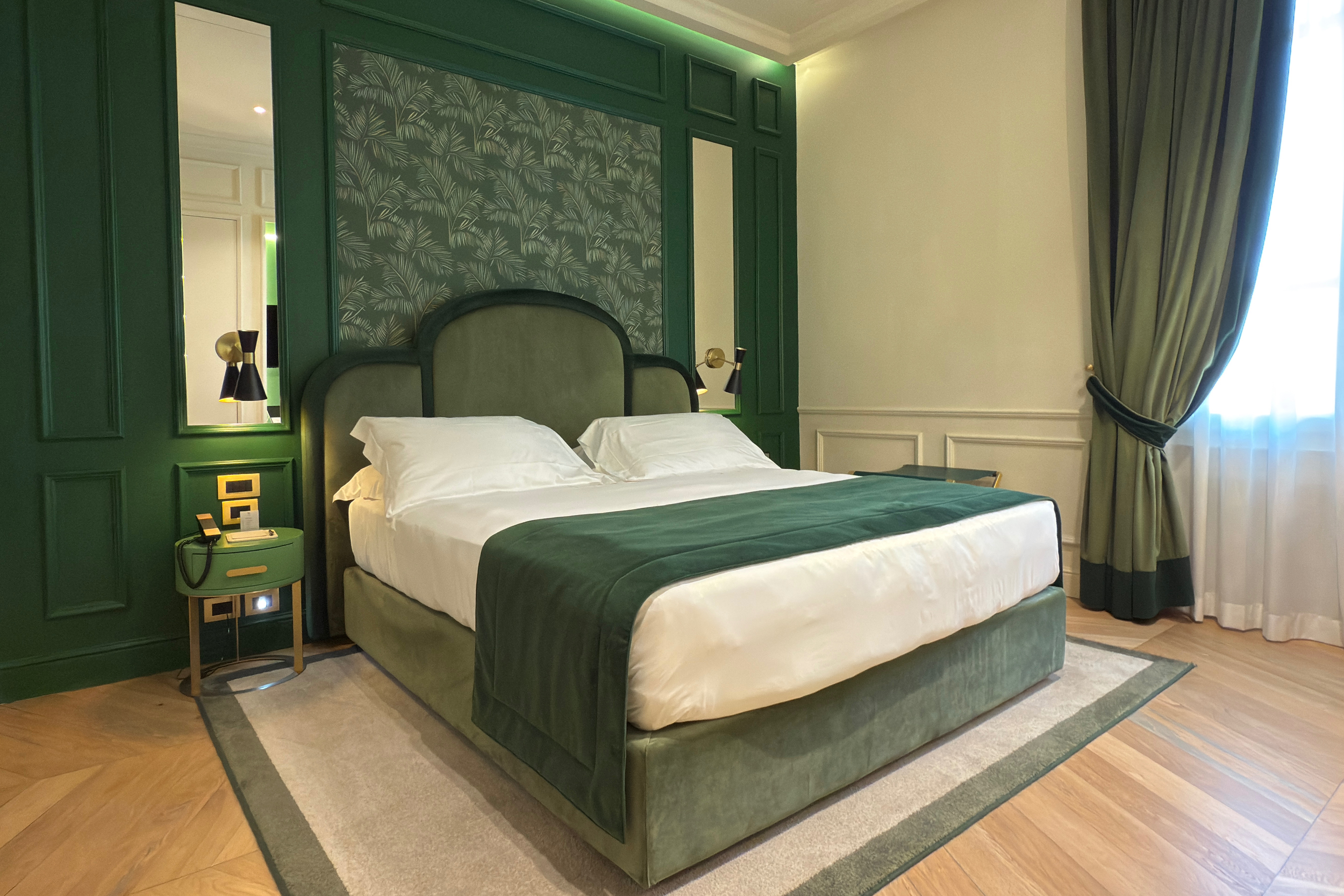 Art Deco luxury suite in Florence with a king-size velvet bed, Marshall speaker, Donatello art book, writing desk, and motion-sensor lights leading to a marble bathroom.