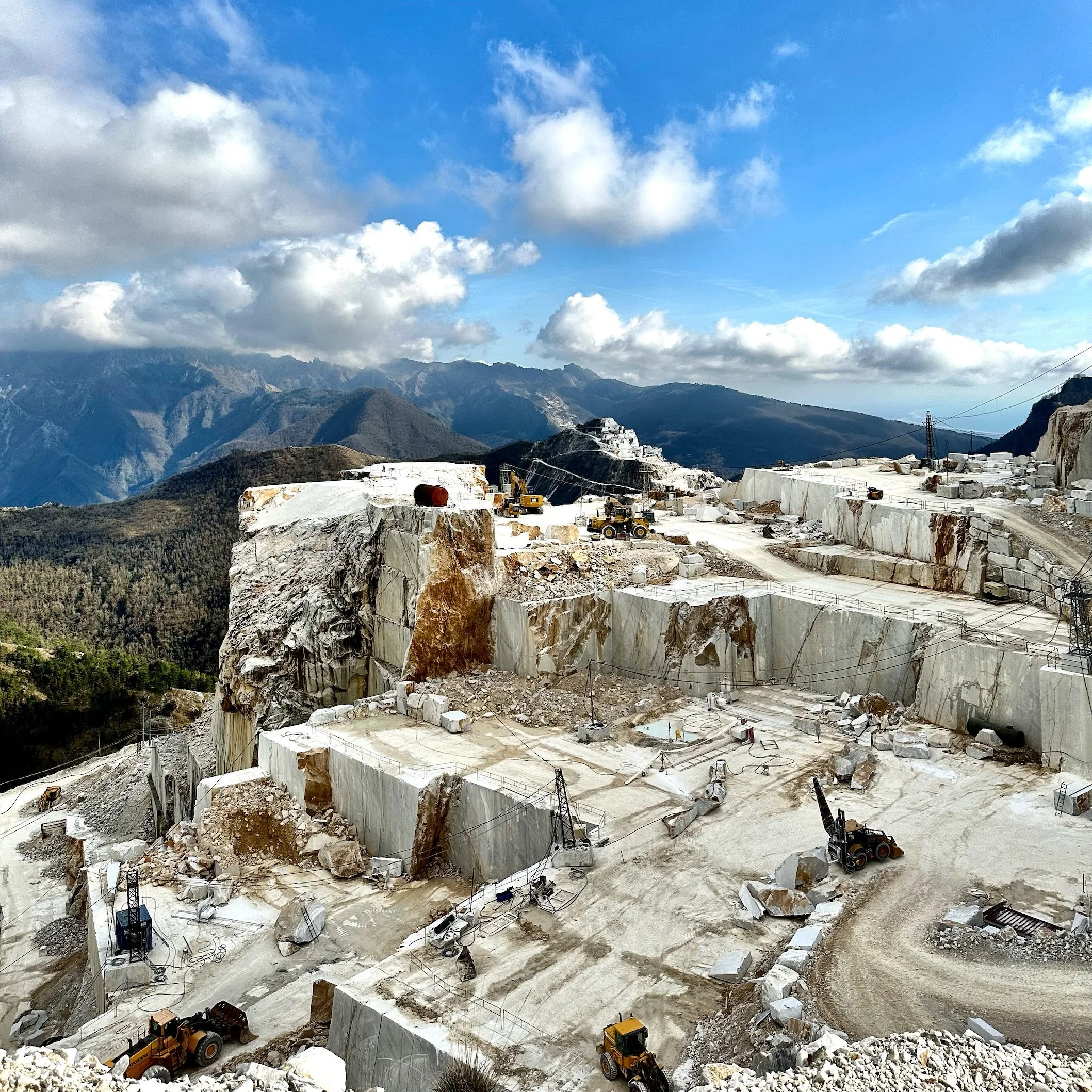 Carrara marble quarries in Tuscany, Italy under a deep blue Mediterranean sky, historic source of marble for Michelangelo’s David and Renaissance sculpture