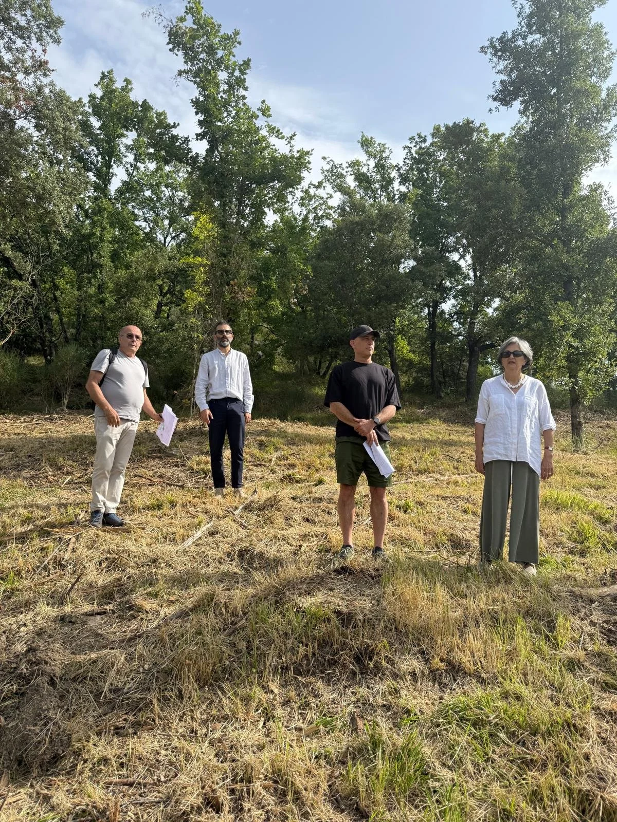 Vinti on the left and Lato on the right with clients on a grassy area surrounded by Umbrian hills.
