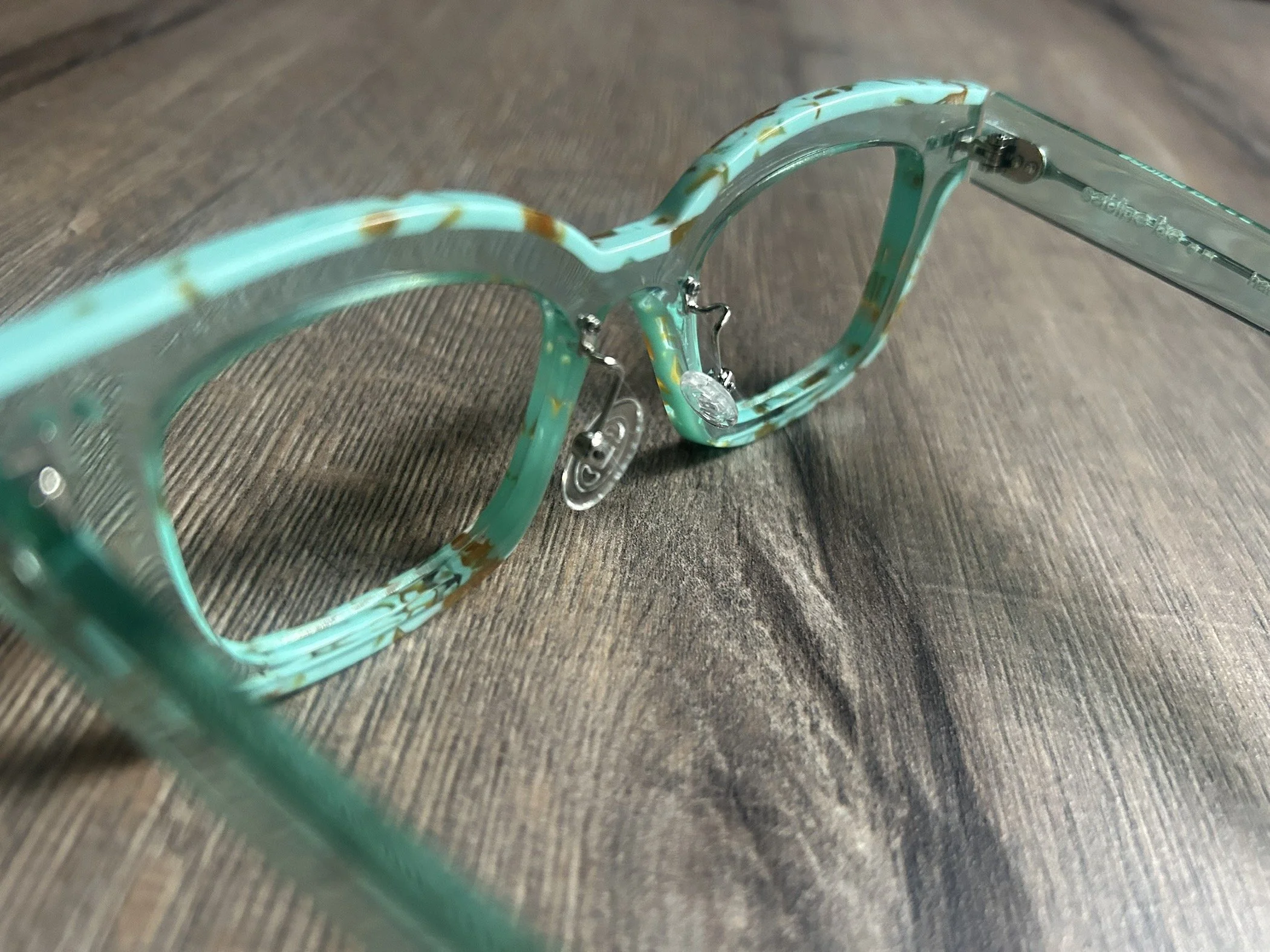 Custom nose pad installation on acetate glasses.