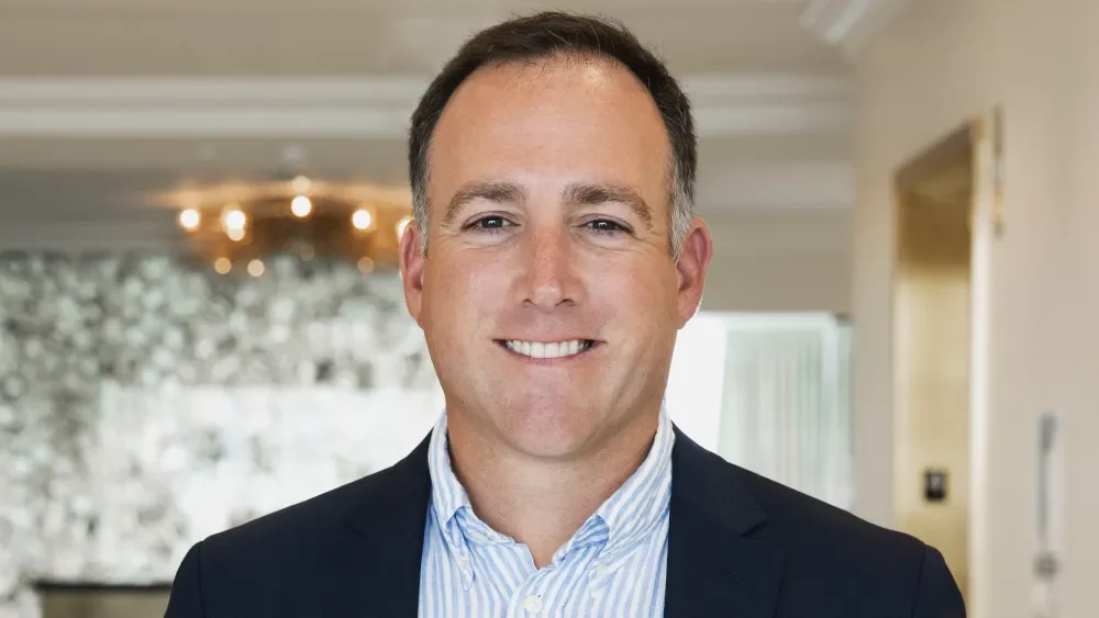 Portrait of a smiling man in a business suit in a modern office environment.