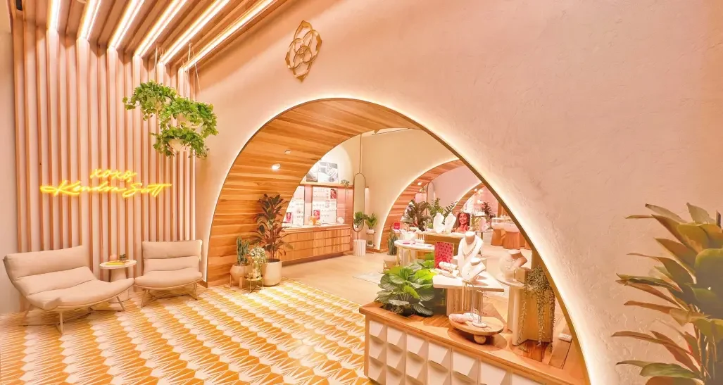 Modern and cozy store with warm lighting, wooden accents, green plants, and stylish seating arrangements.