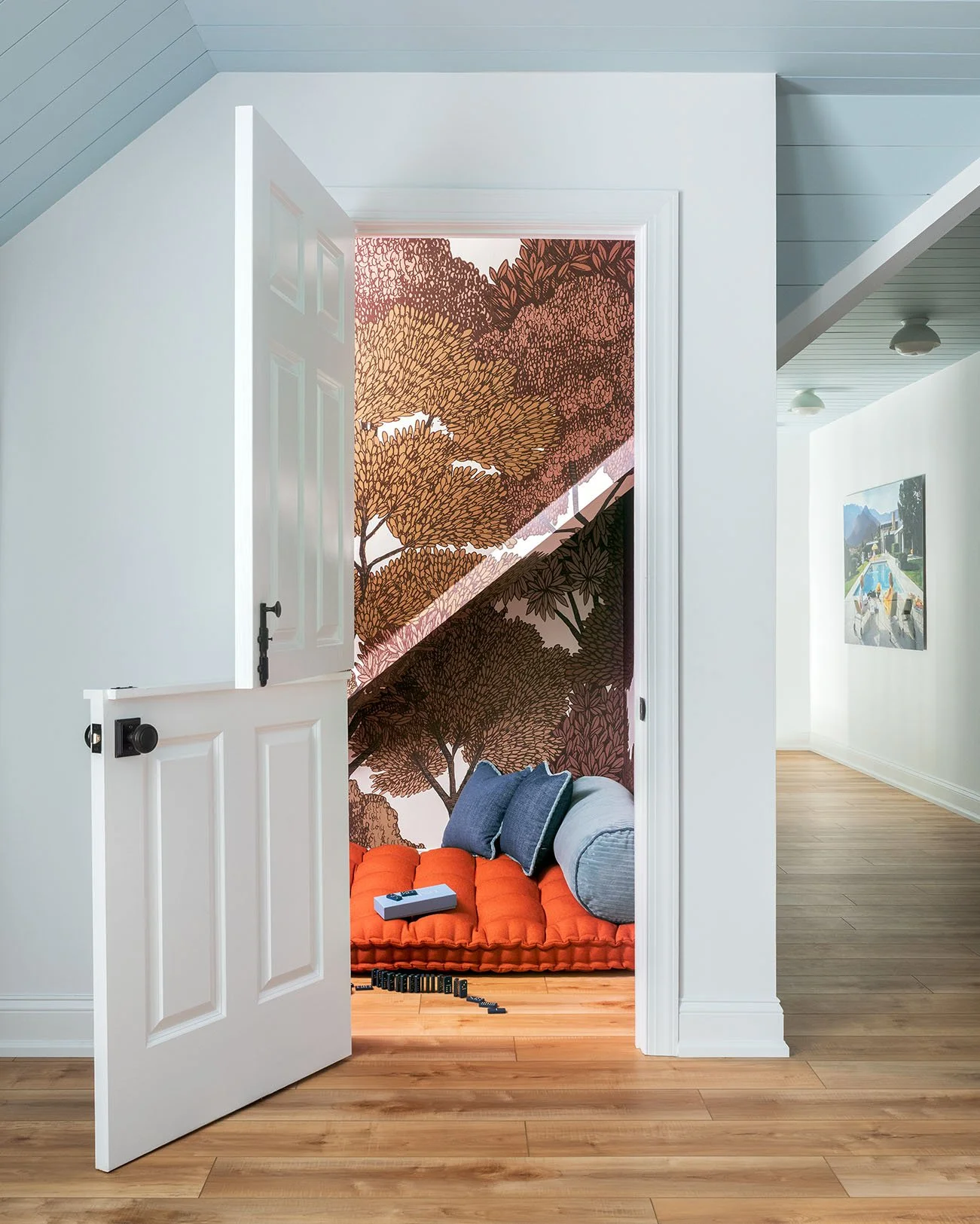 Half door reading nook with wallpaper and orange cushion