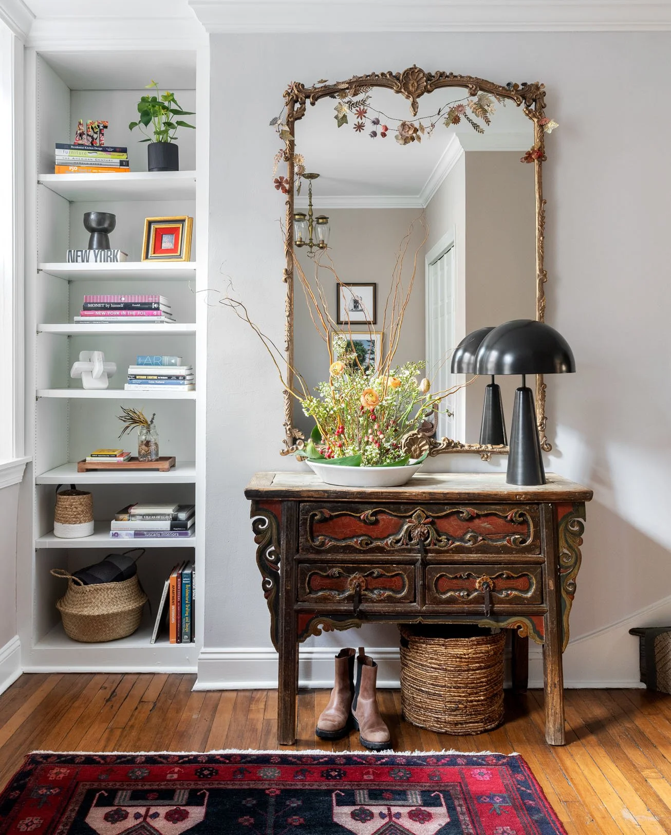 Antique chest of drawers in foyer with stacked built in shelves