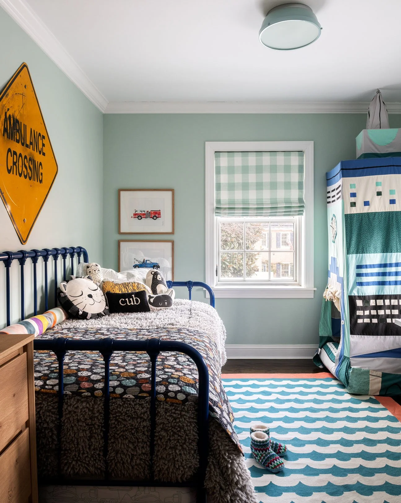 Black trundle bed in a child's room with light green walls