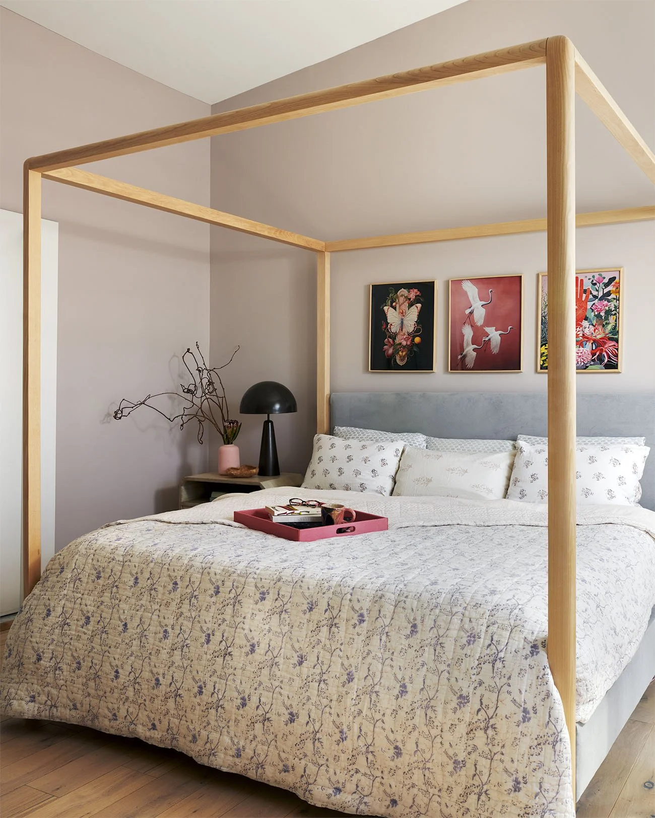 Wooden poster bed with tray and three art prints above