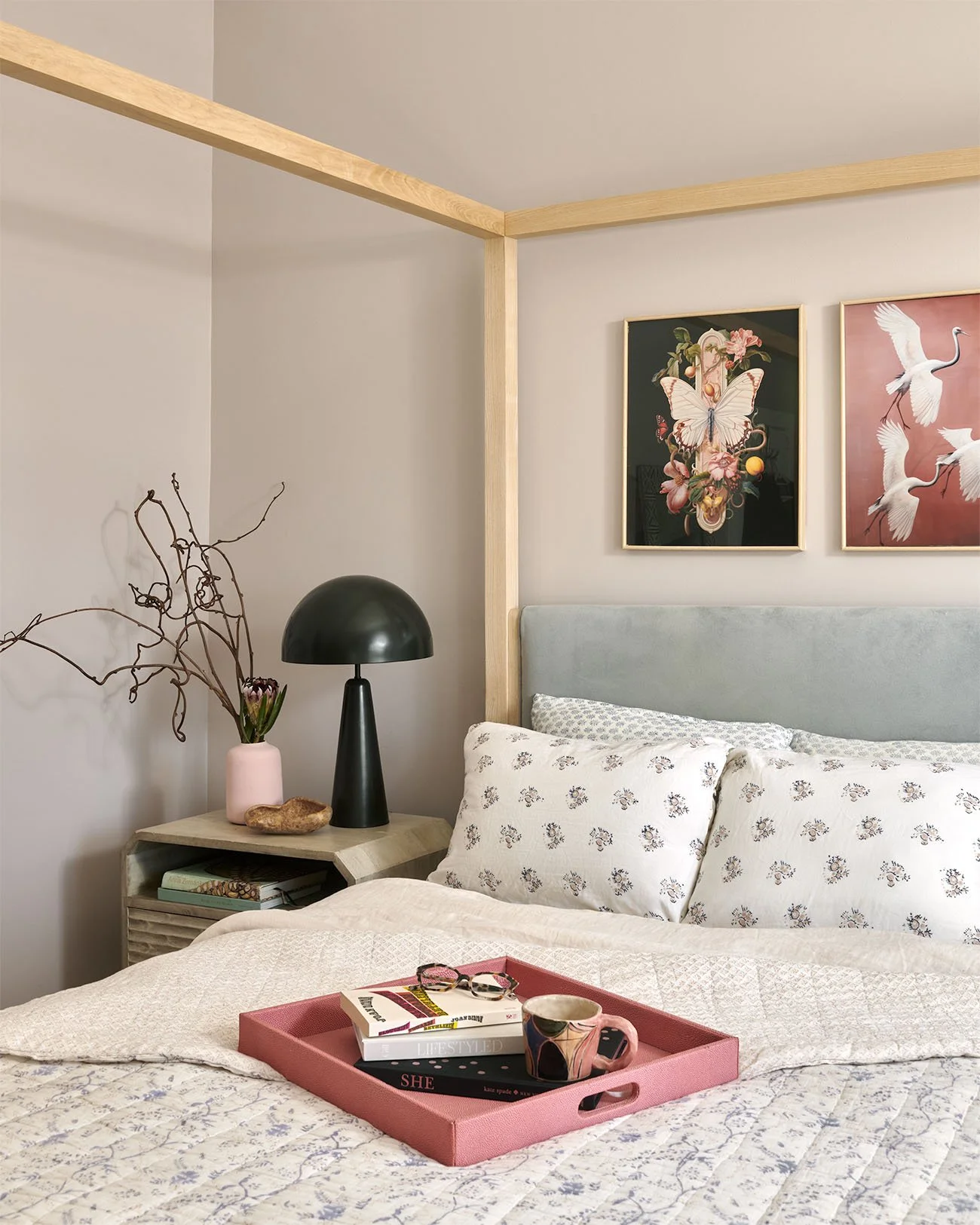 Black modern lamp next to bed with a pink tray on it