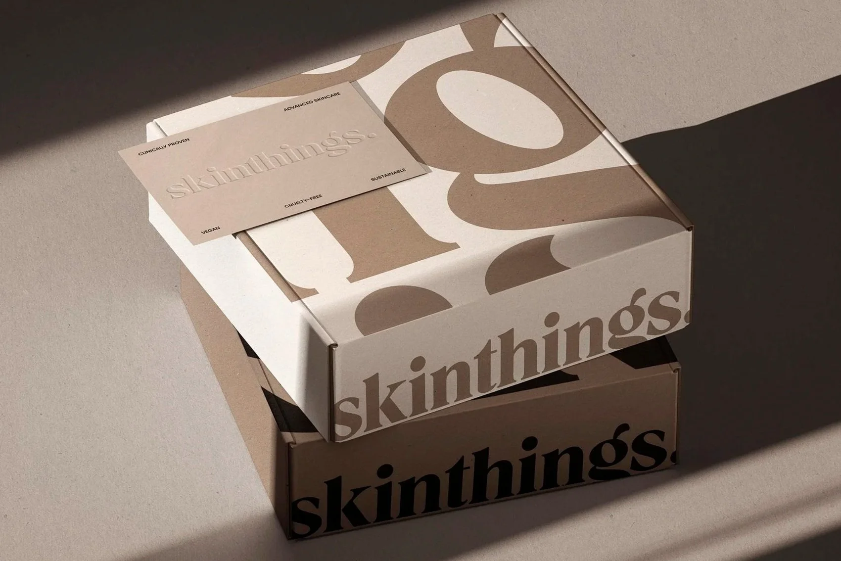 Two stacked boxes labeled 'skinthings' with a beige and black color scheme, sunlight casting shadows