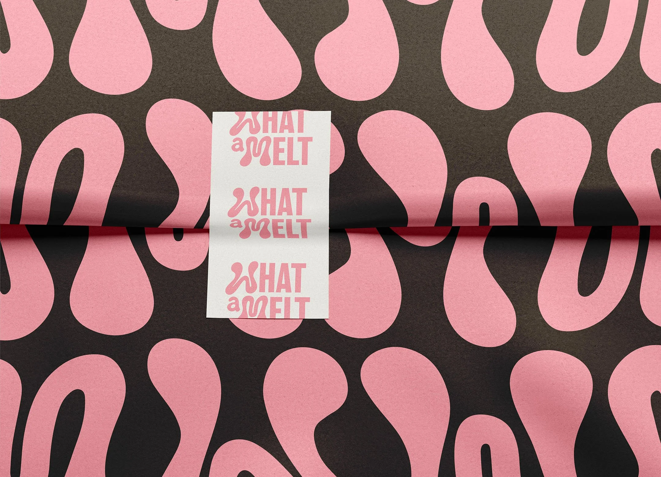 Wrapped package with black and pink abstract patterned paper and a white label with pink text that reads "WHAT a MELT" repeated three times.