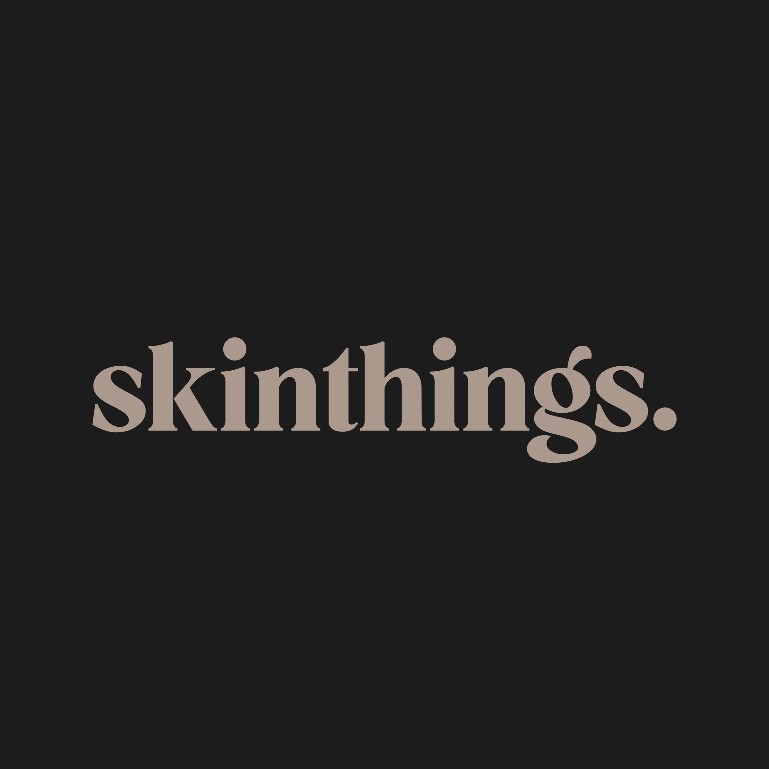The word 'skinthings.' in light brown text centered on a dark background.