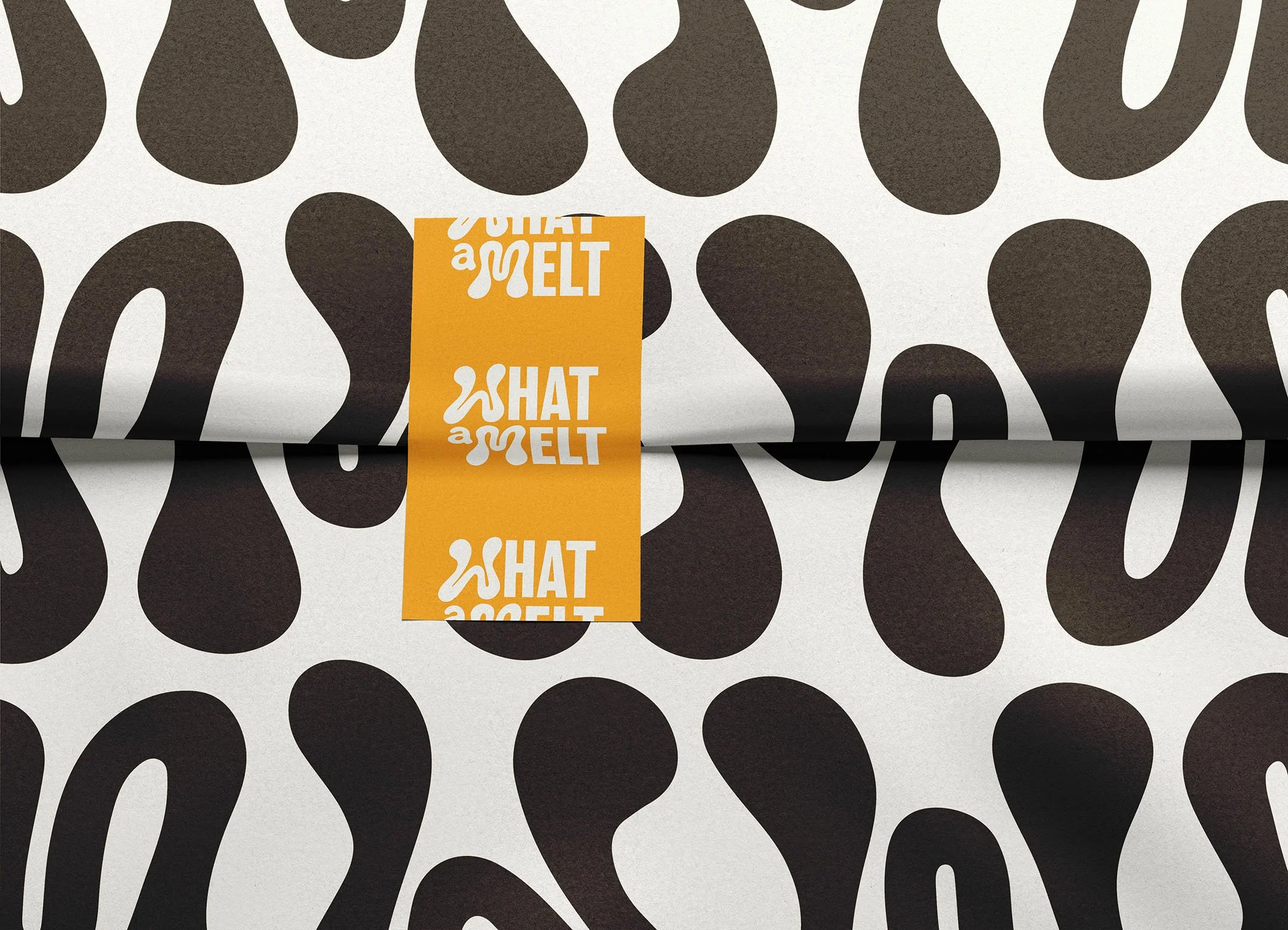 Close-up of black and white patterned wrapping paper with an orange tag that says 'SHAT A MELT'.