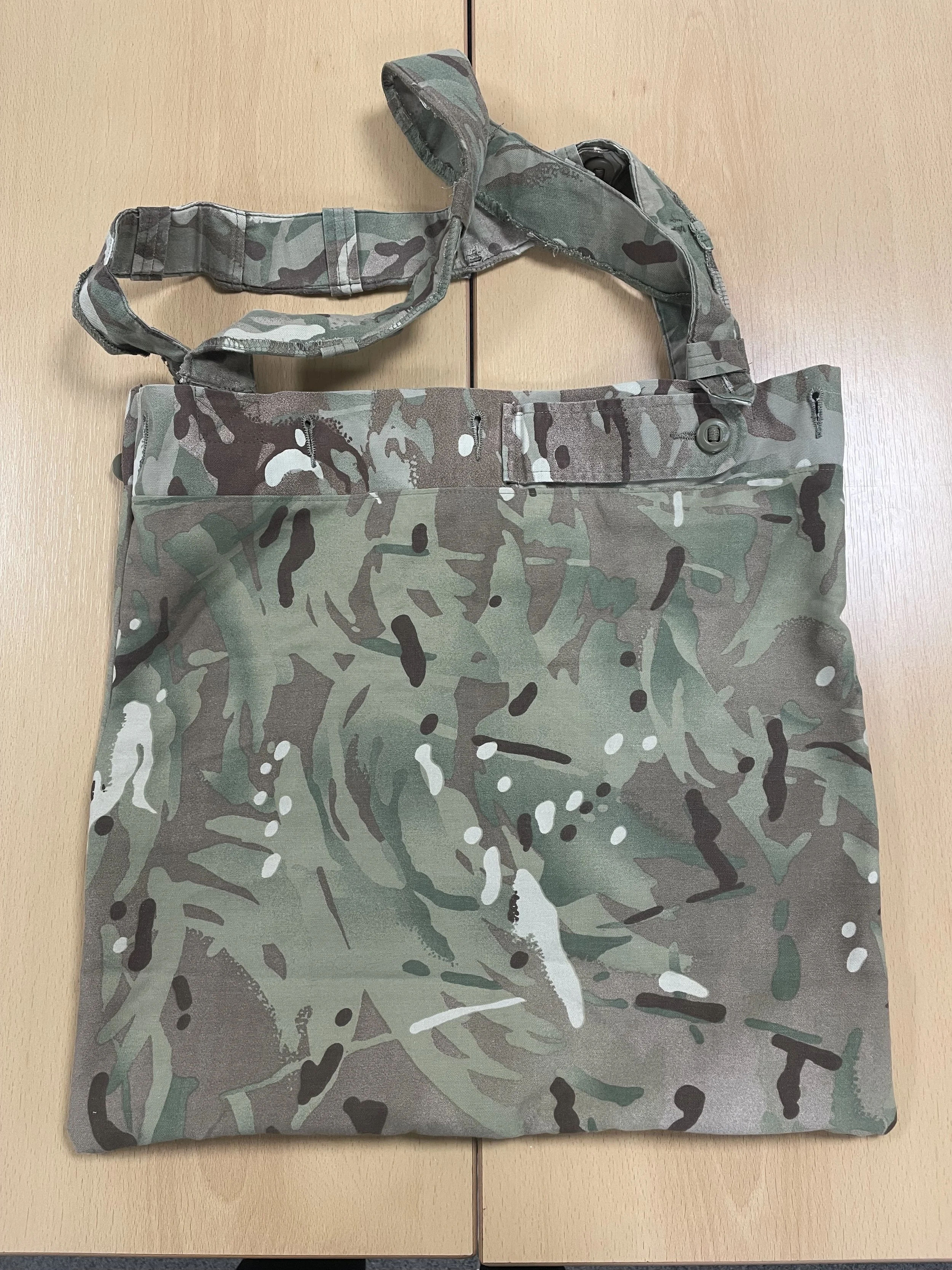Camouflage tote bag with matching strap, laid flat on wooden surface.